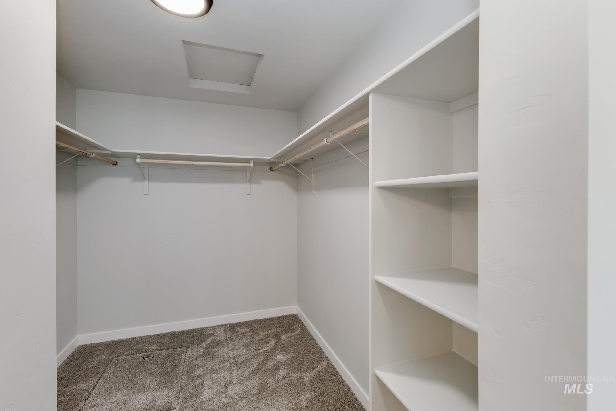 Walk in closet with carpet and attic access