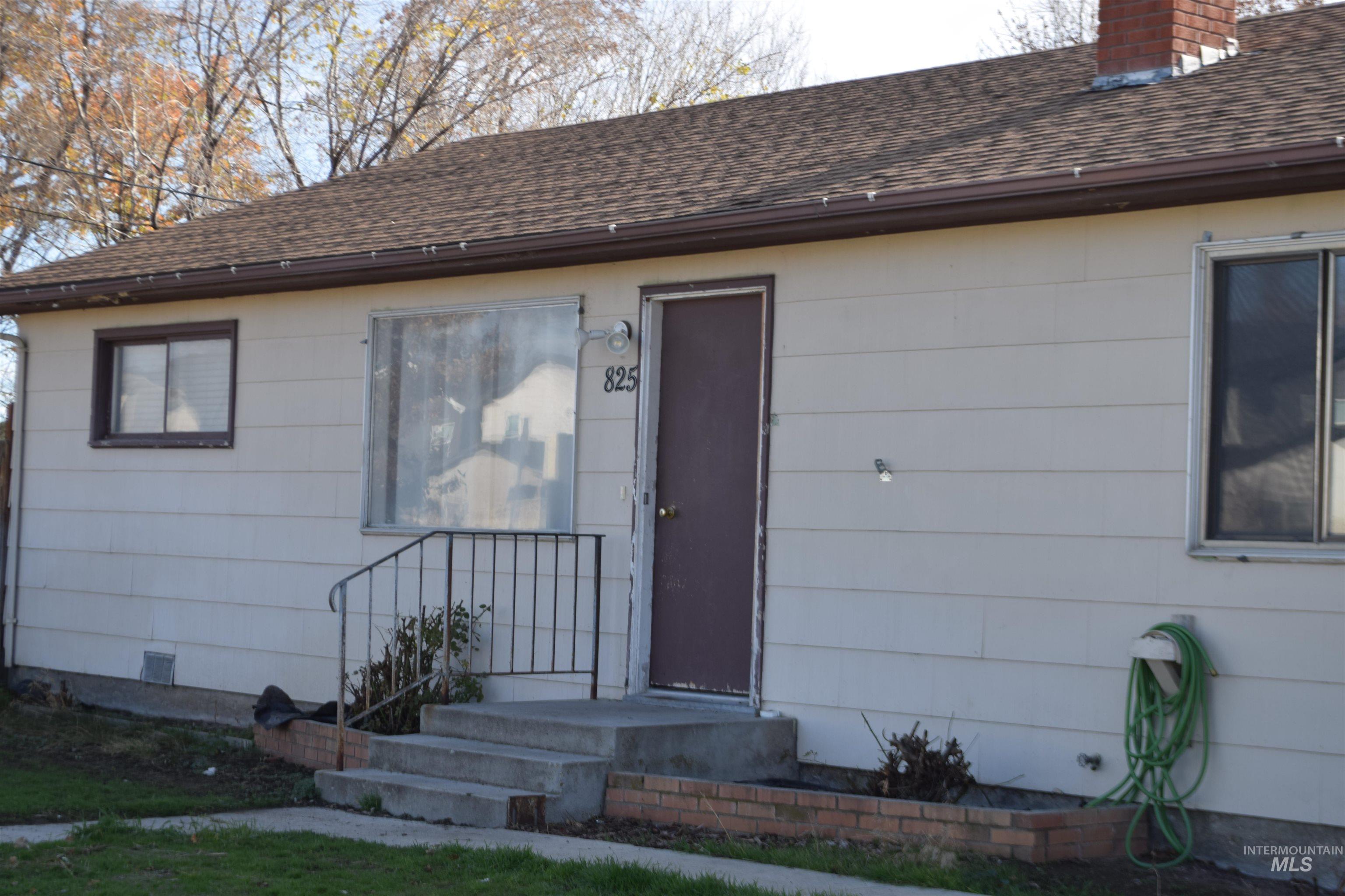 Doorway to property with a chimney and a shingled roof
