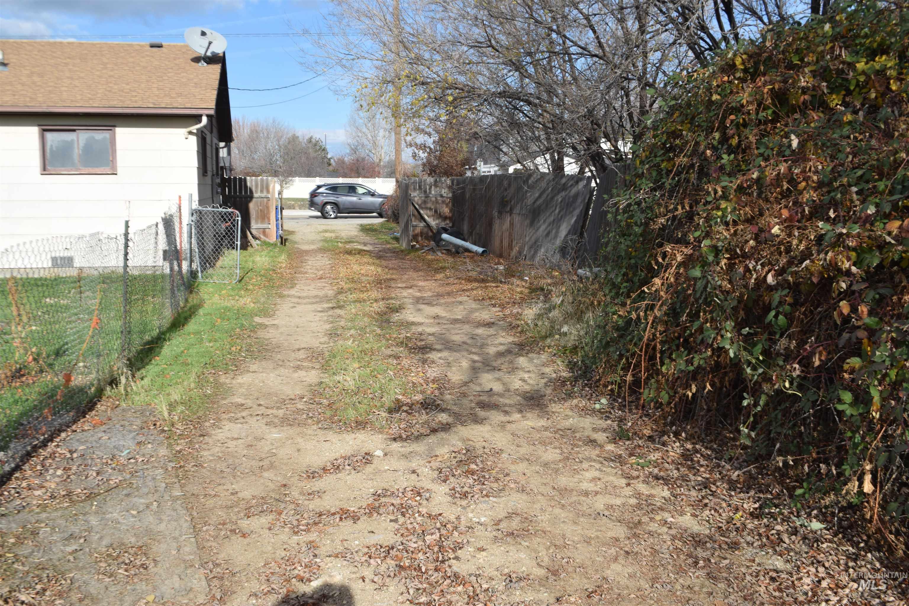 View of dirt / gravel road featuring a gated entry