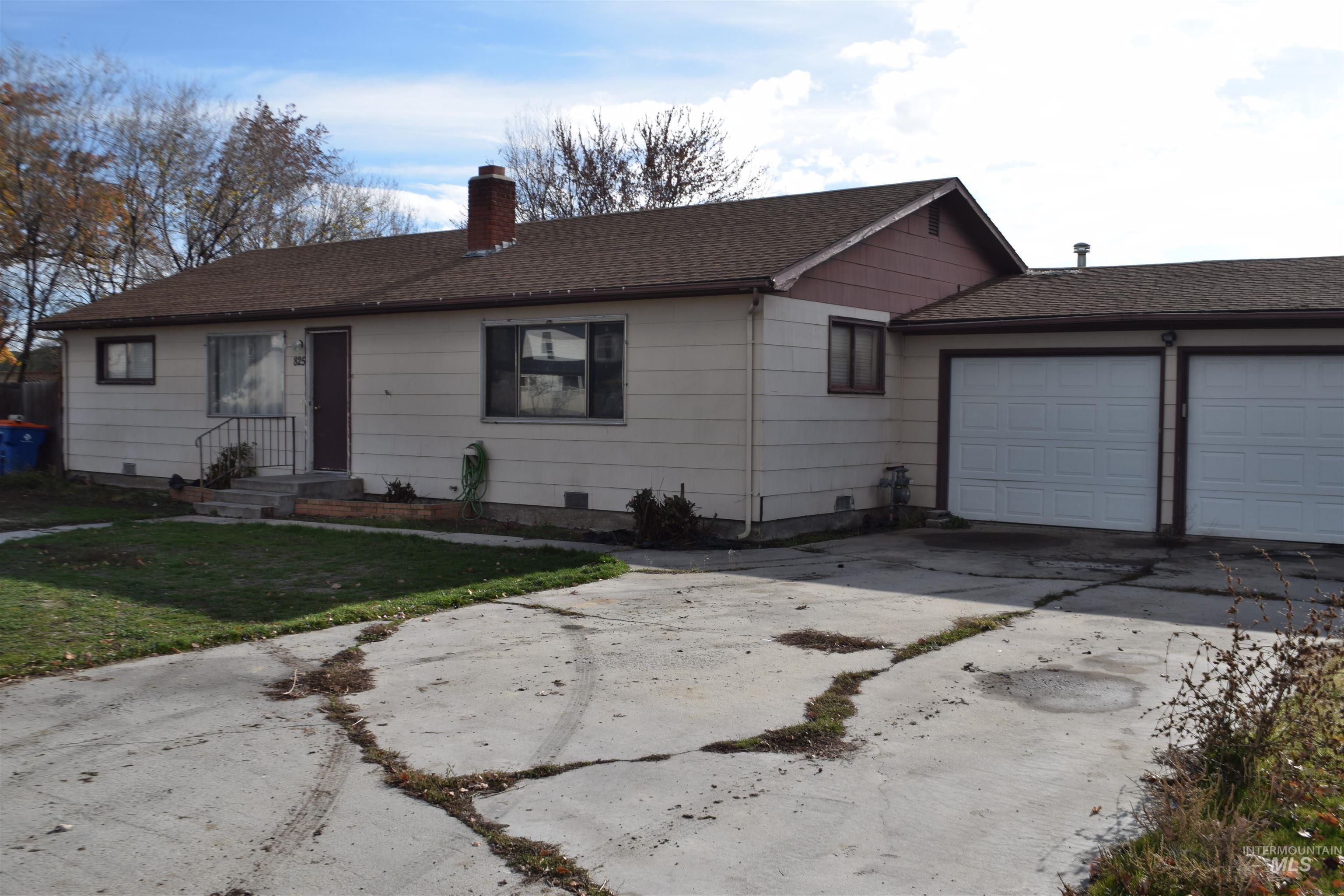 Ranch-style home featuring driveway, roof with shingles, a chimney, a garage, and a front yard
