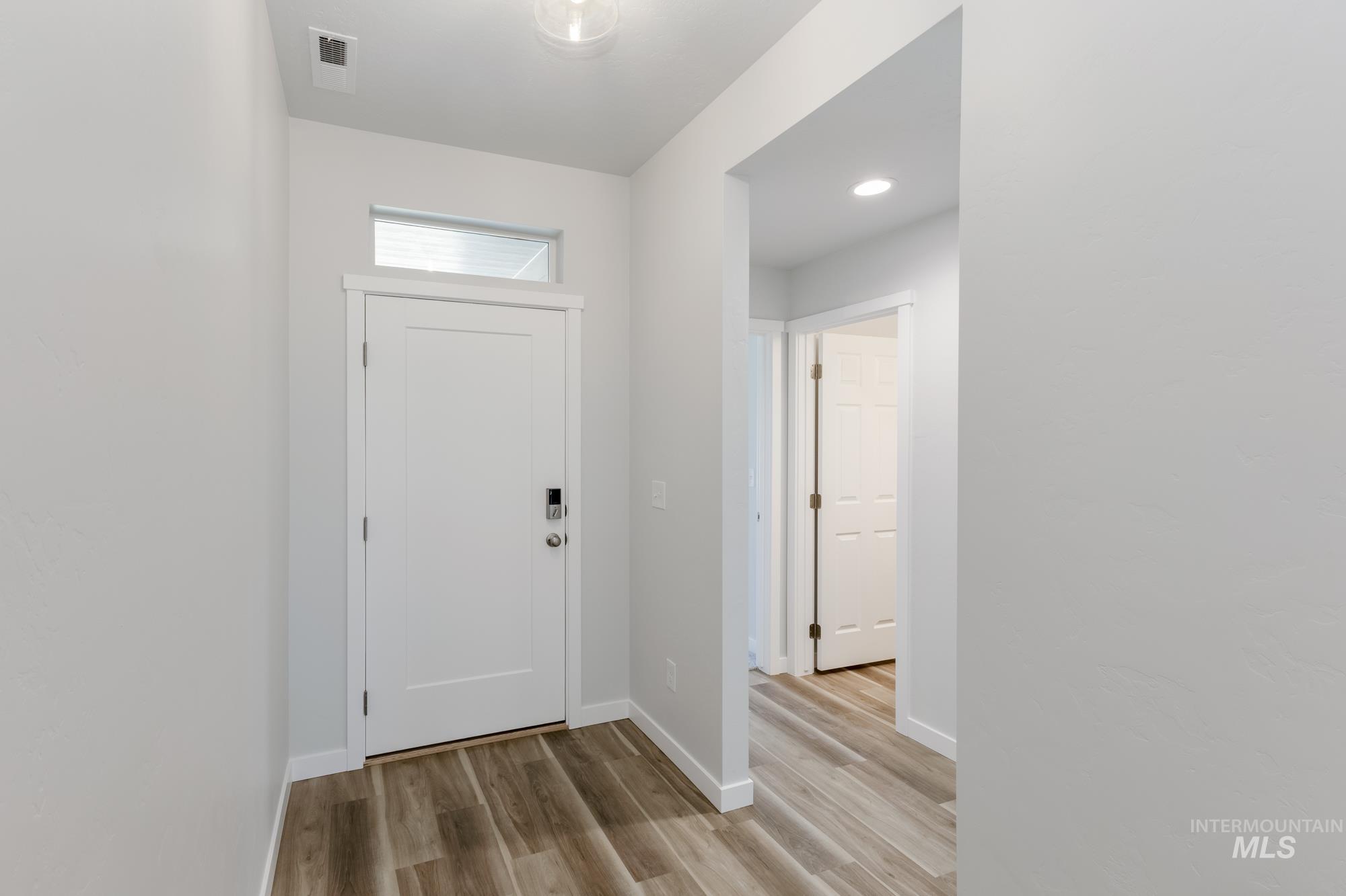 Entryway featuring baseboards and light wood-type flooring