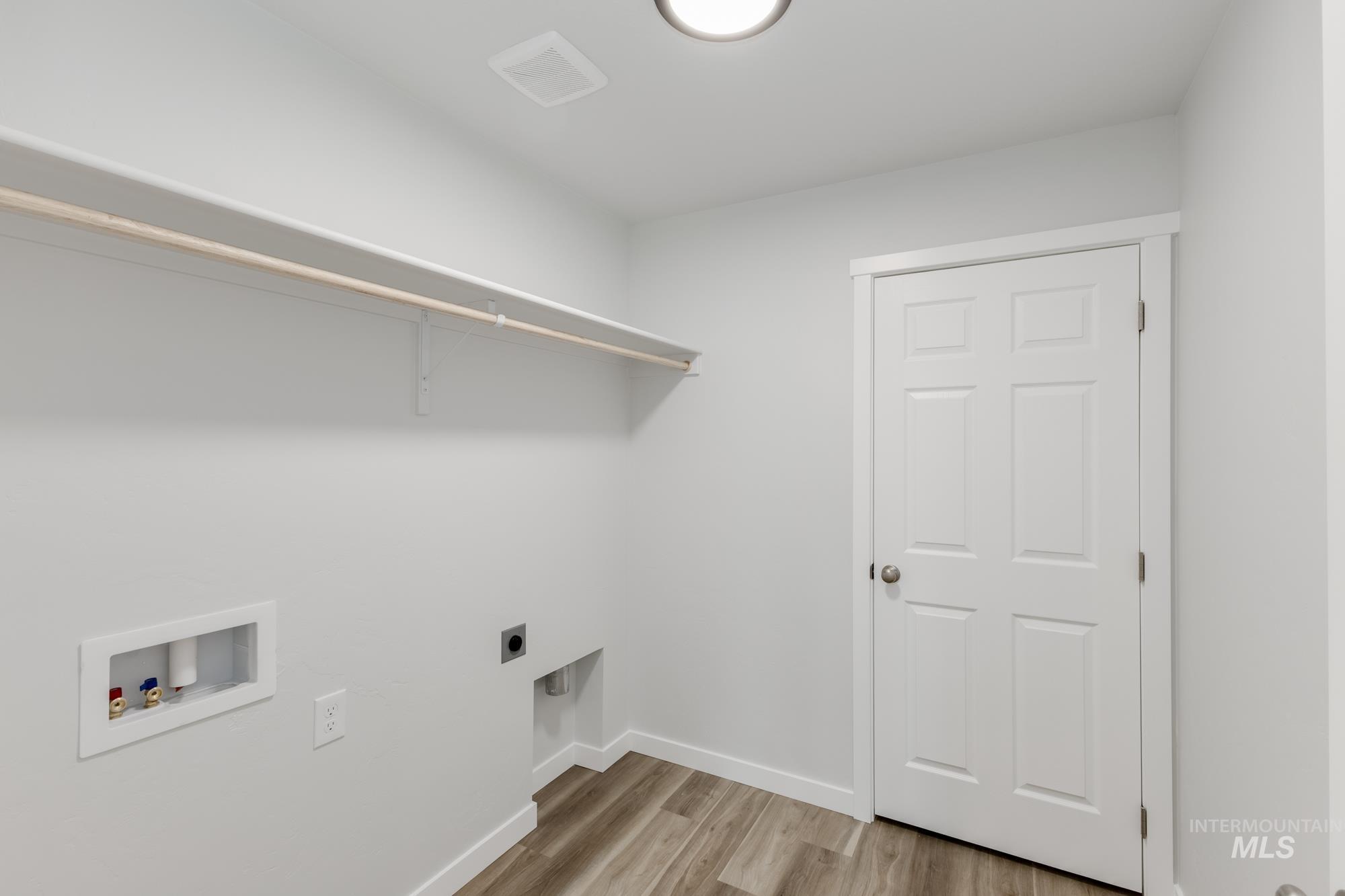 Laundry area featuring light wood-style floors, hookup for a washing machine, and hookup for an electric dryer