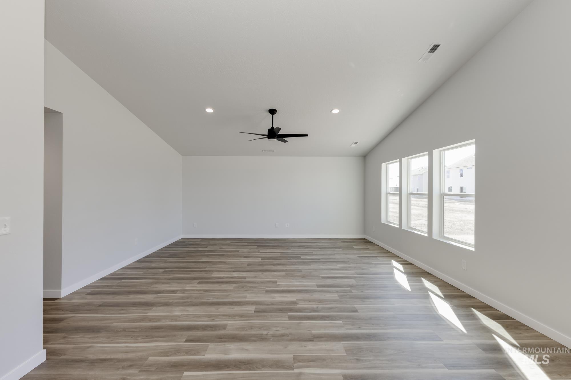 Spare room with lofted ceiling, light wood-style floors, recessed lighting, and ceiling fan