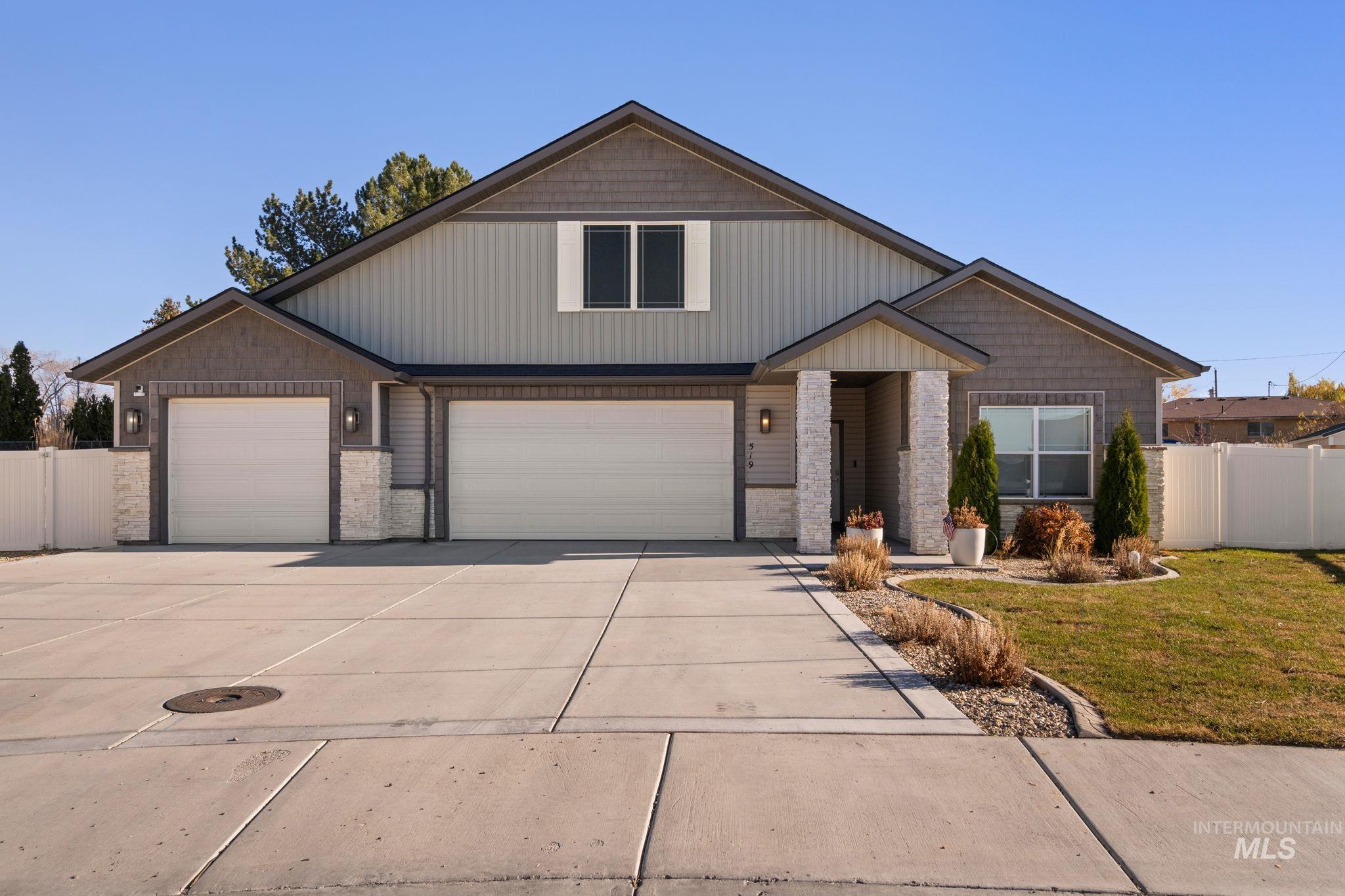 View of front of home with driveway and stone siding