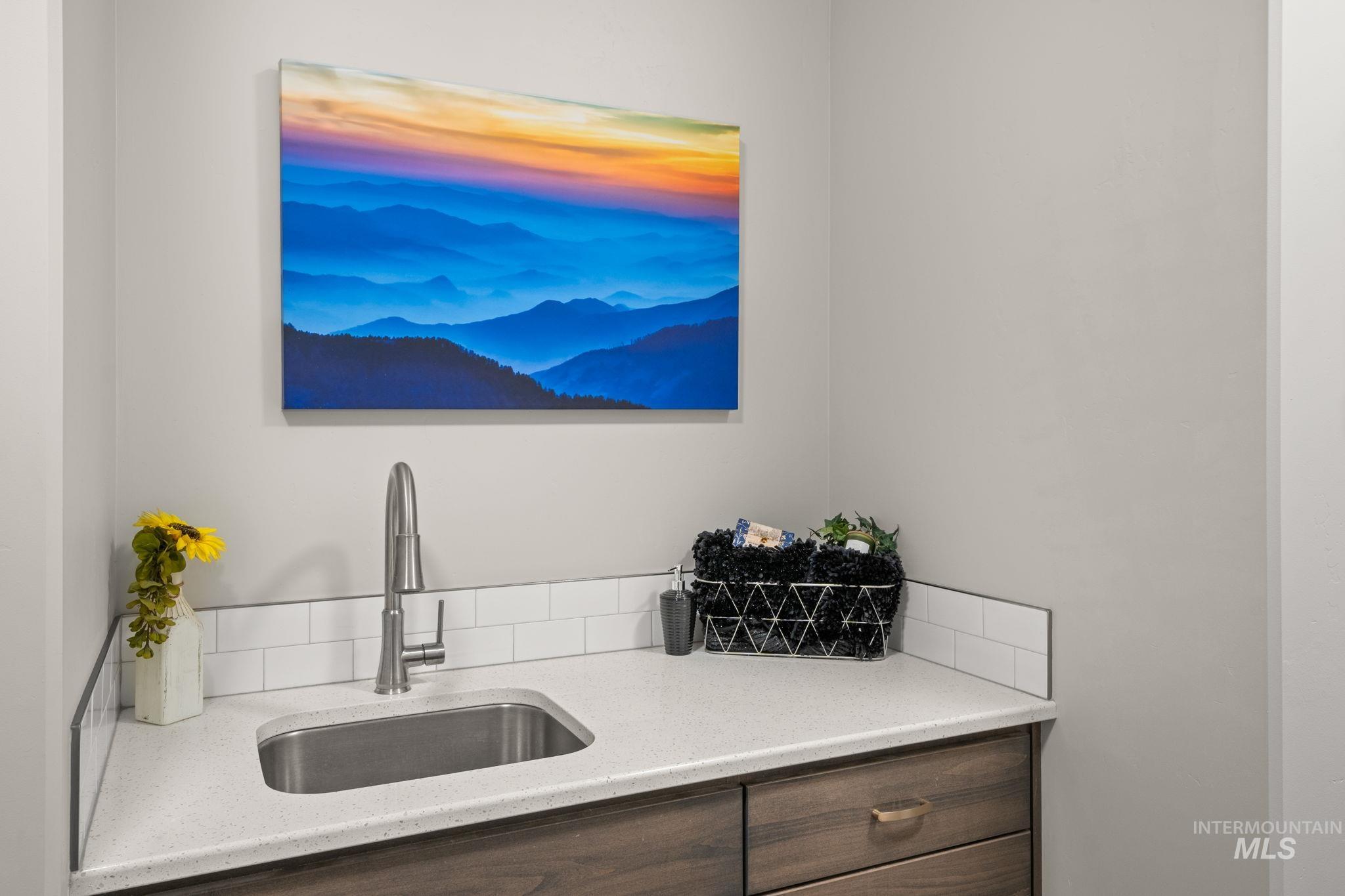 Kitchen featuring light stone countertops and dark brown cabinetry