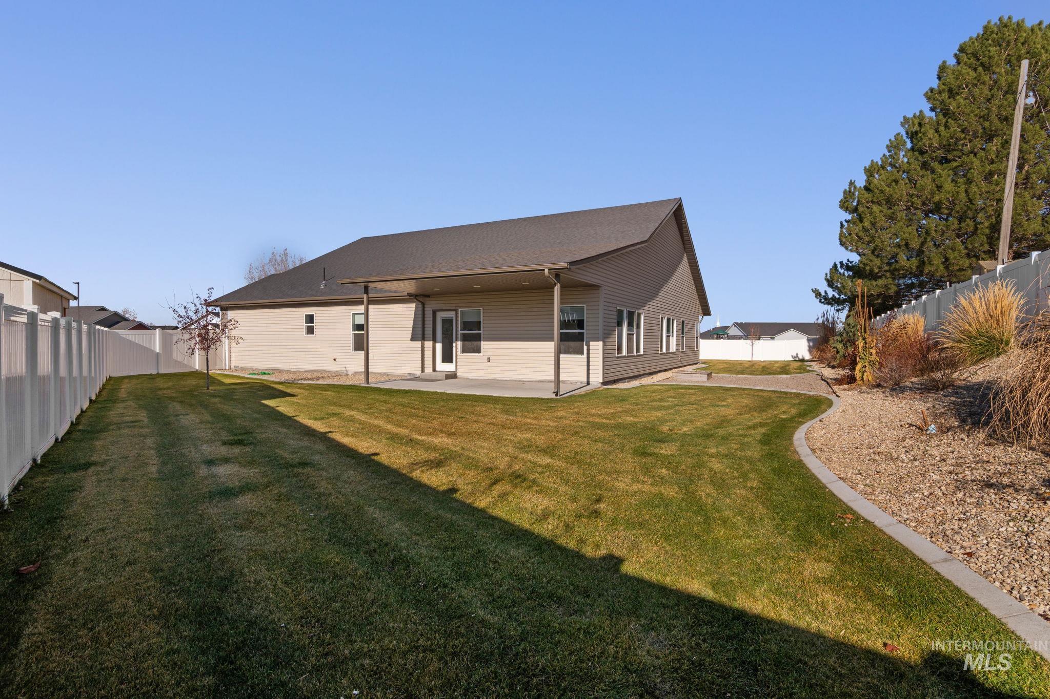Rear view of property with a fenced backyard and a patio