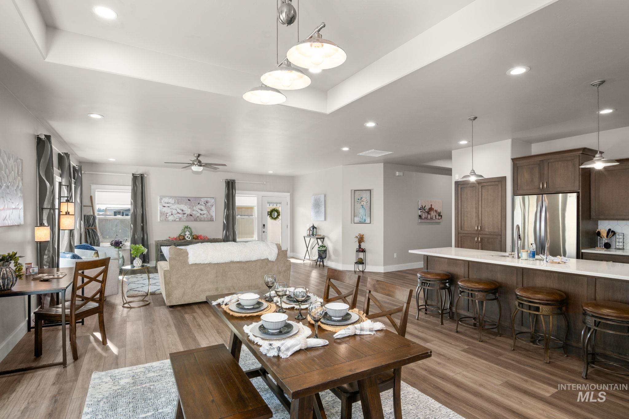 Dining room featuring ceiling fan, recessed lighting, a tray ceiling, and light wood finished floors