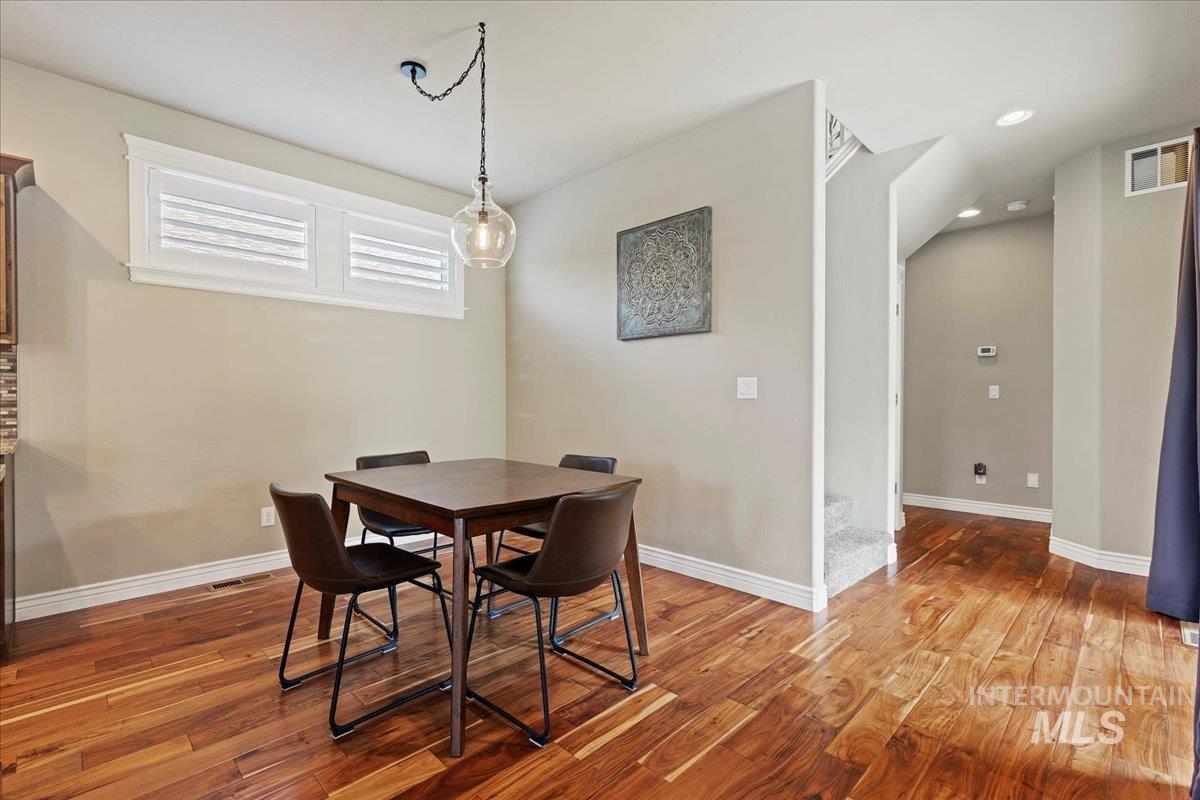 Dining space with wood finished floors and recessed lighting