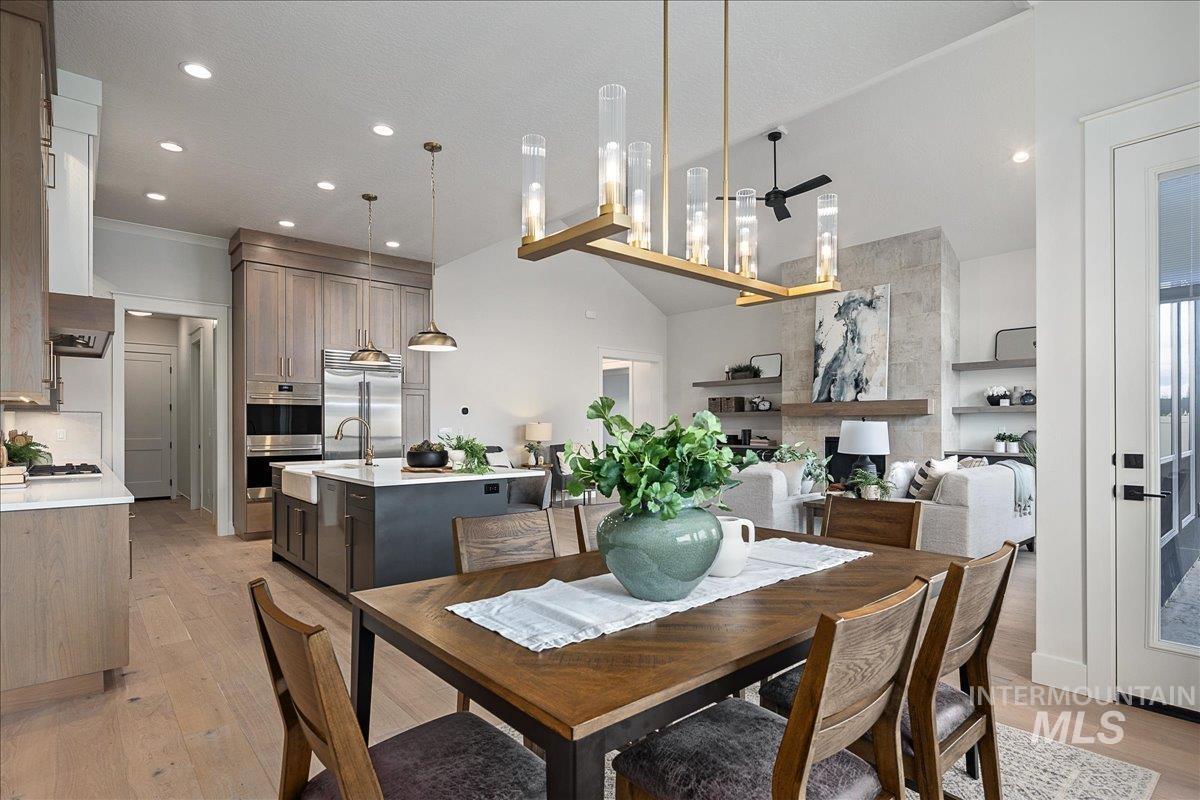 Dining room with light wood-style flooring, recessed lighting, and vaulted ceiling