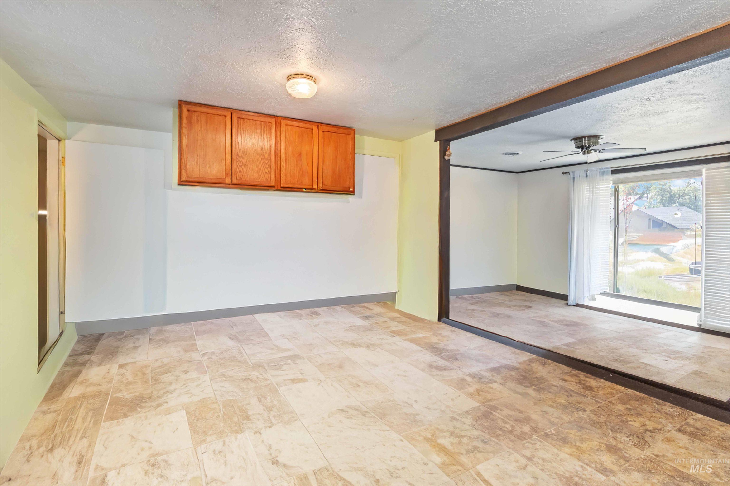 Unfurnished room with a textured ceiling and a ceiling fan