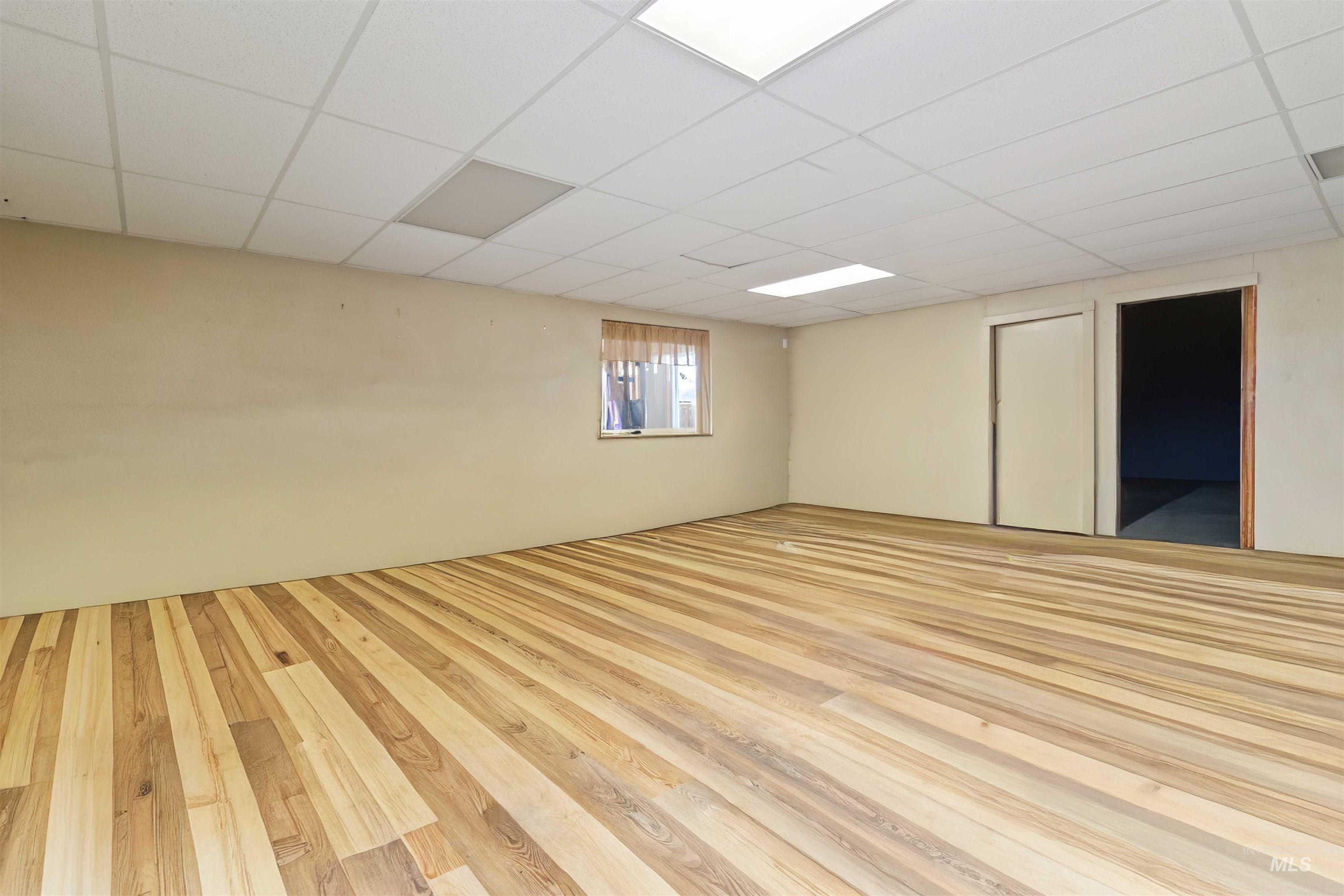 Spare room with a drop ceiling and hardwood / wood-style floors