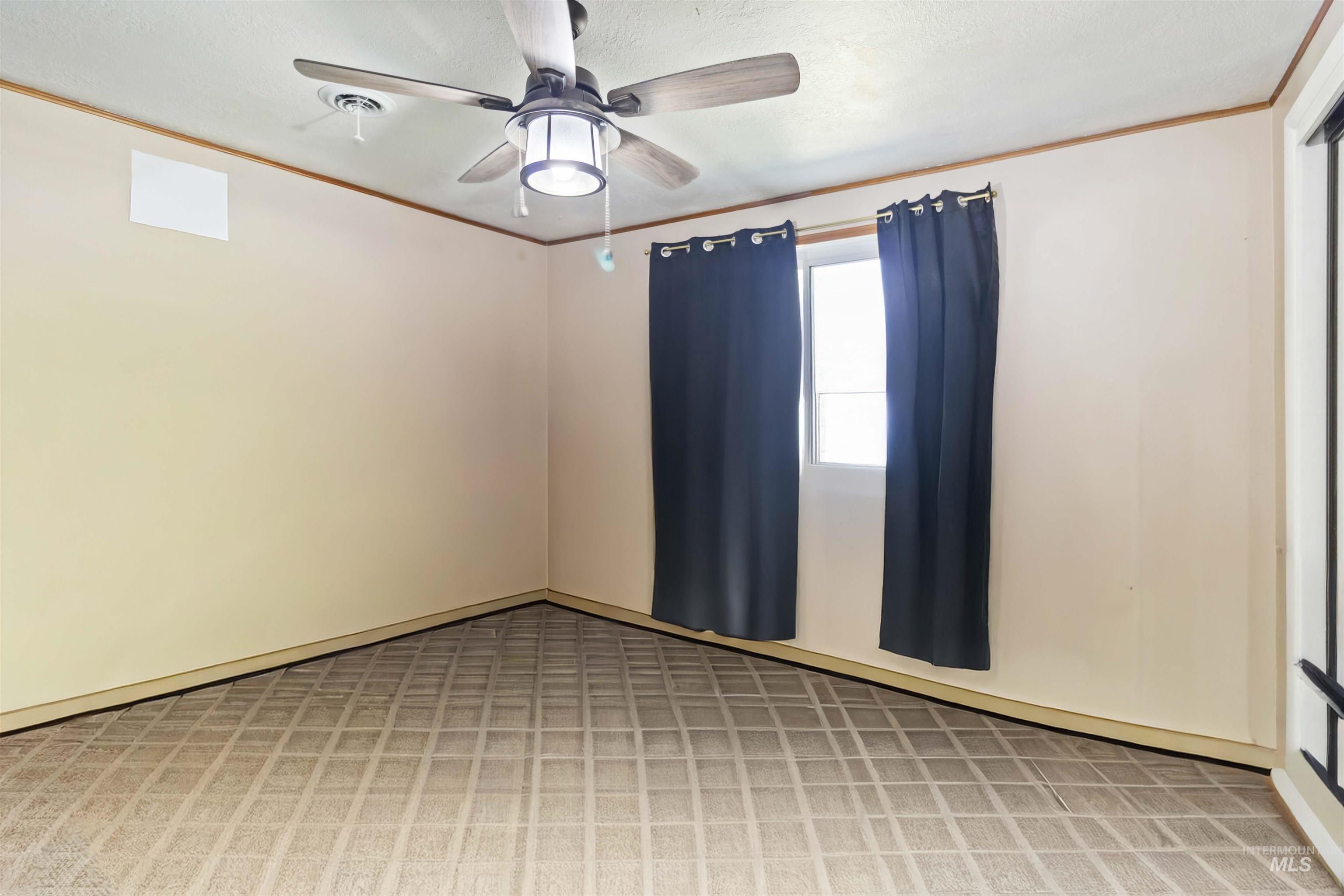 Spare room with crown molding and ceiling fan