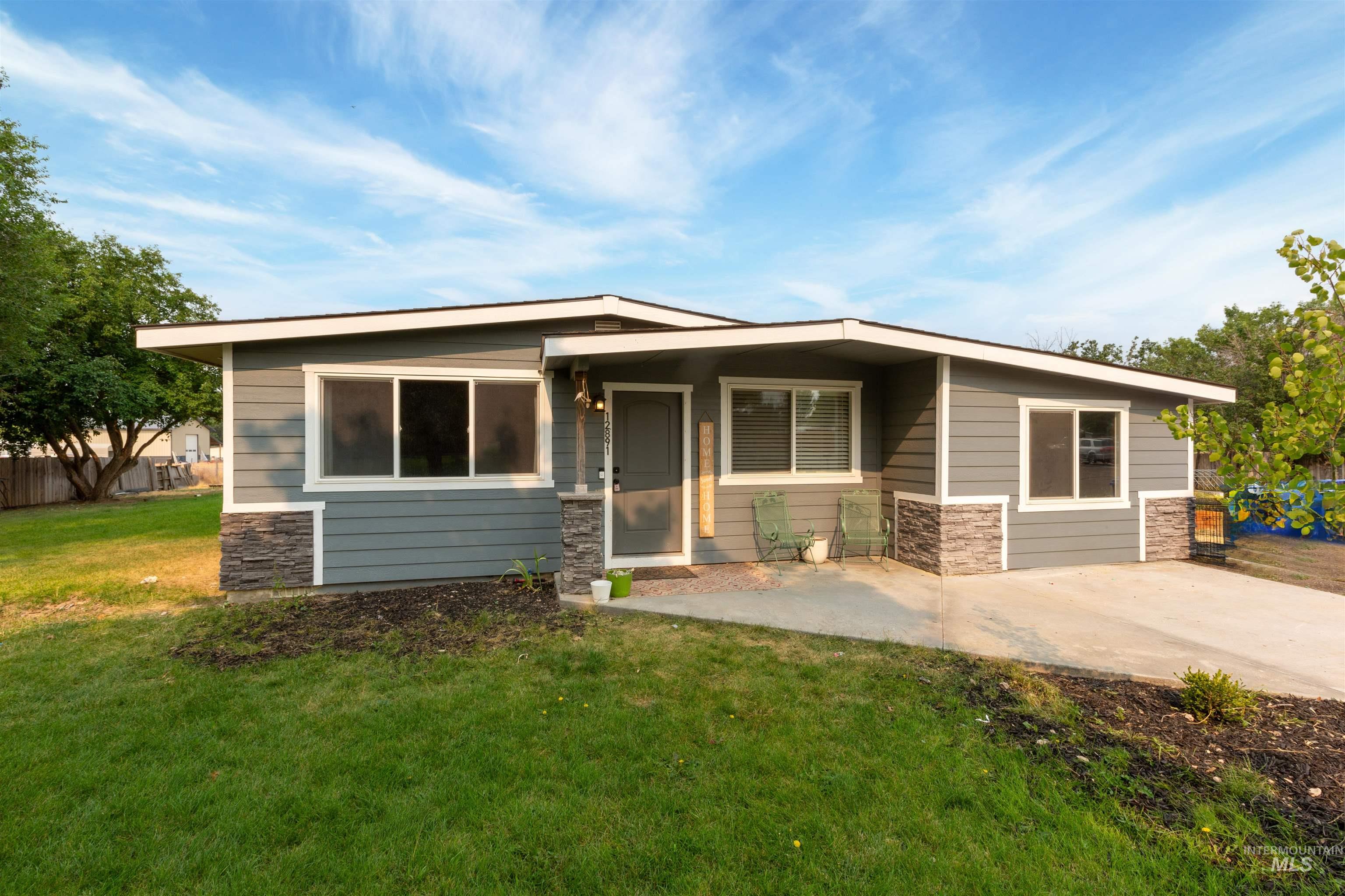 View of front facade with stone siding and a patio