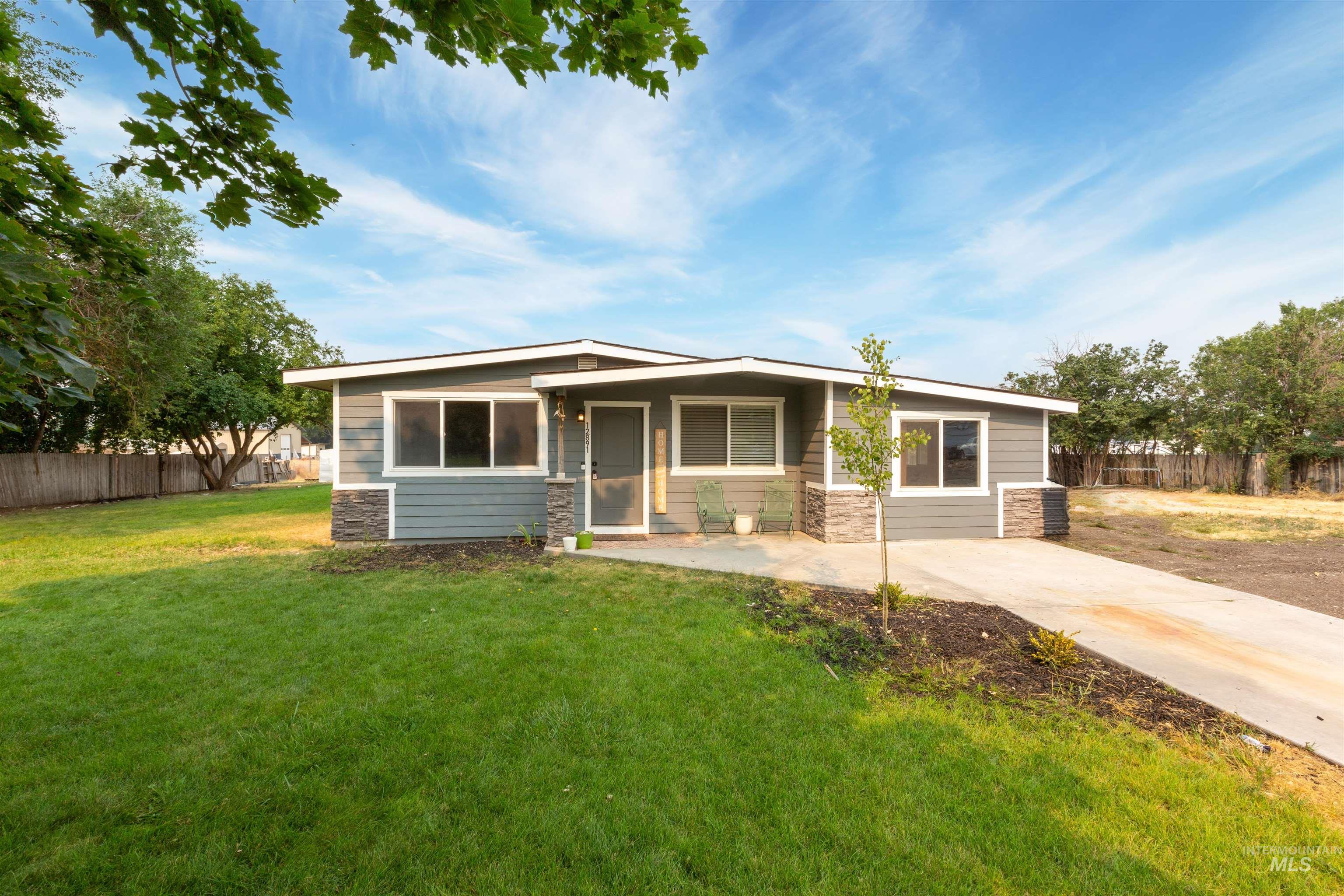 View of front of property featuring stone siding and a patio area