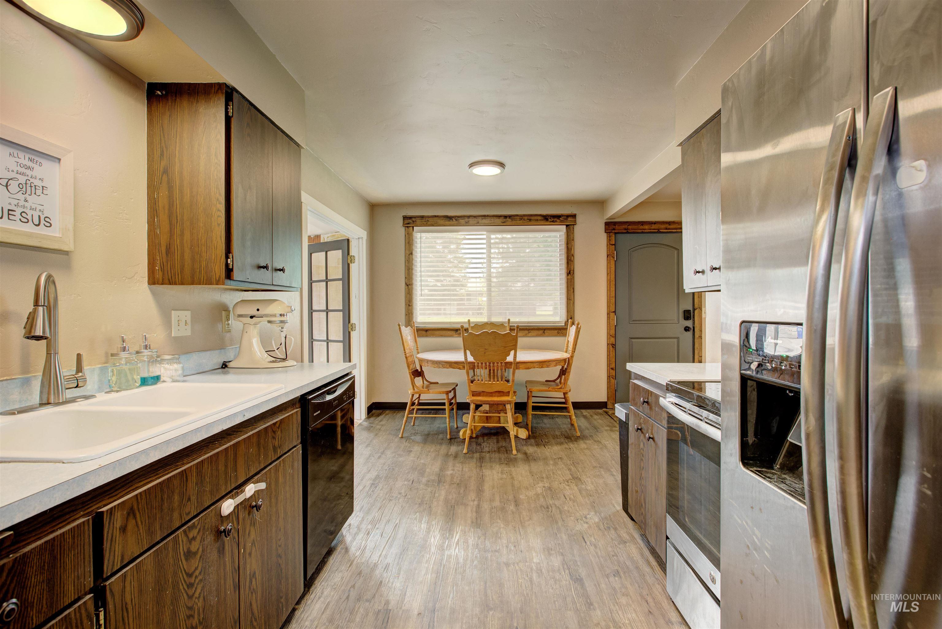 Kitchen with appliances with stainless steel finishes, light countertops, and light wood-style floors