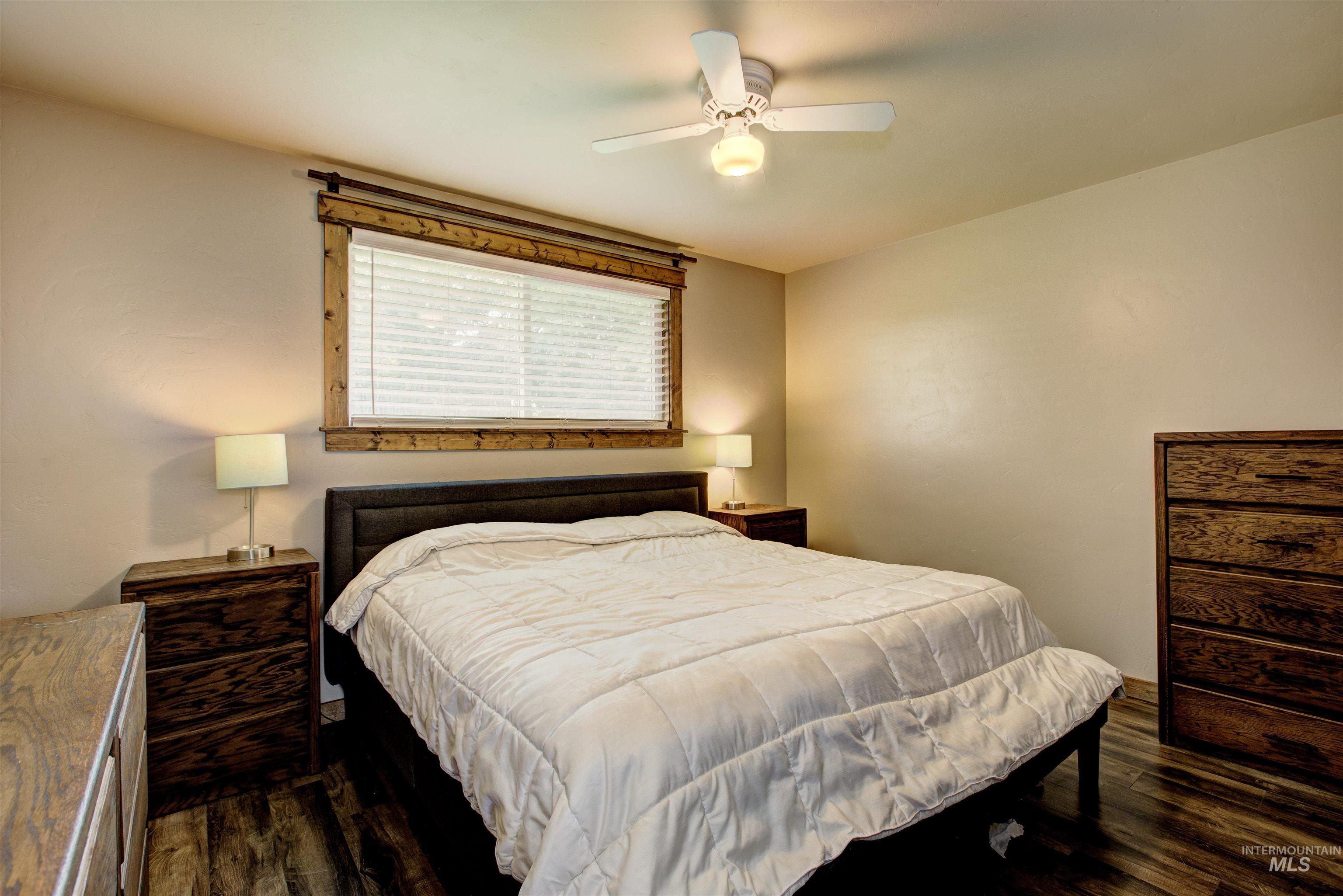 Bedroom with dark wood finished floors and a ceiling fan