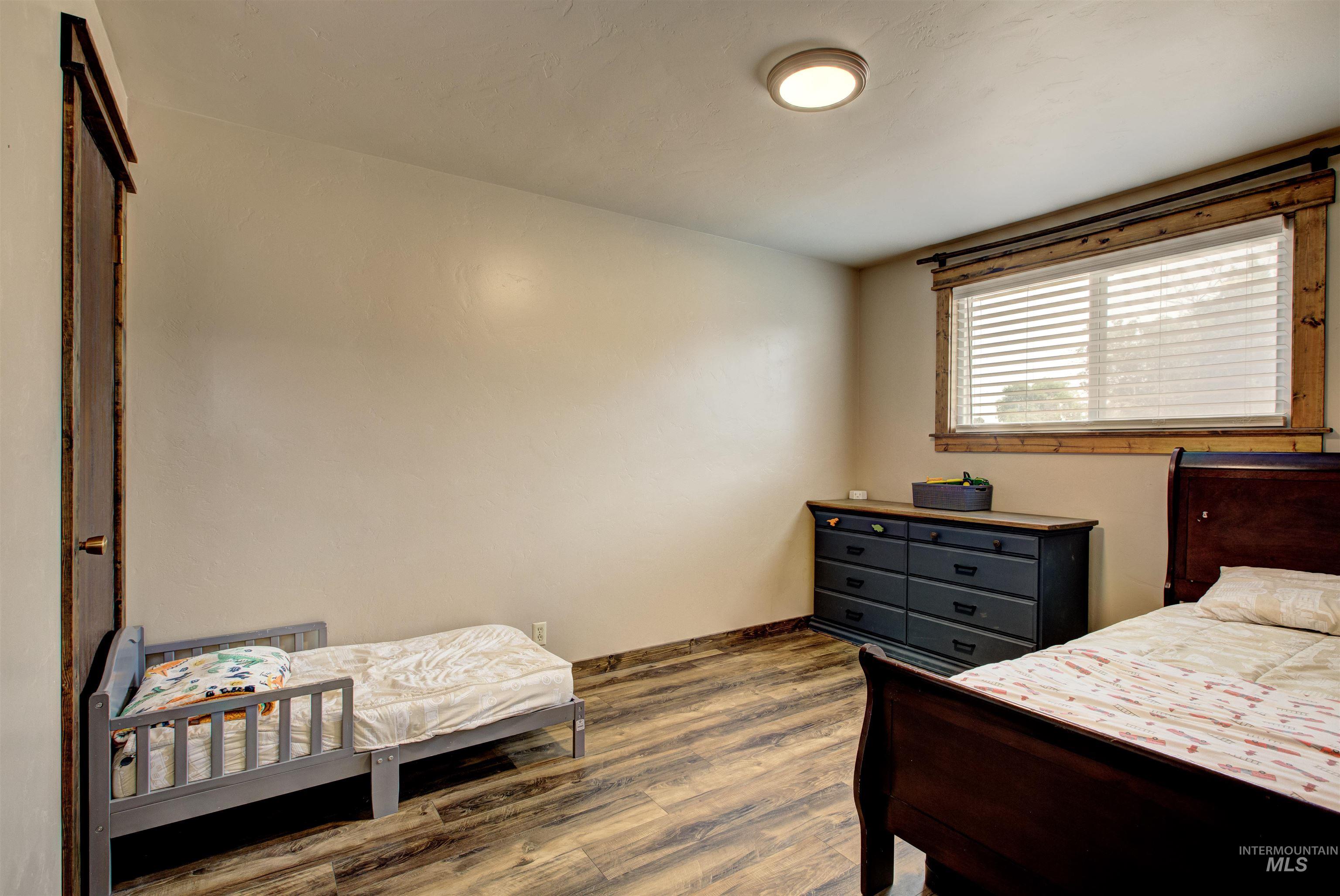 Bedroom with dark wood finished floors and baseboards