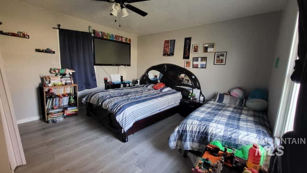 Bedroom with wood finished floors and a ceiling fan