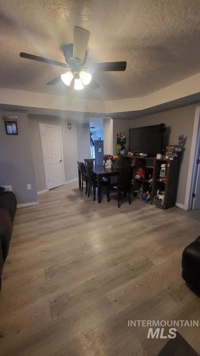 Dining space with light wood-type flooring and a ceiling fan