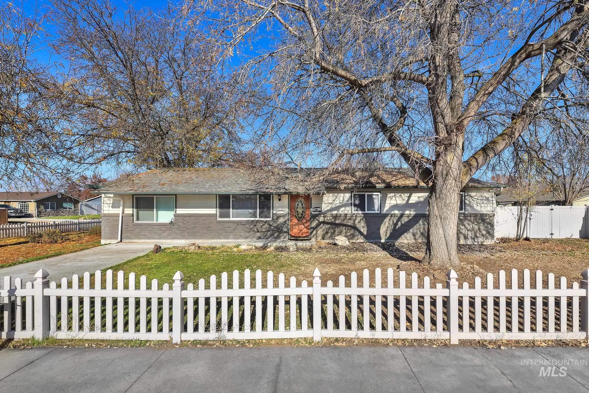 Ranch-style home with brick siding and a fenced front yard