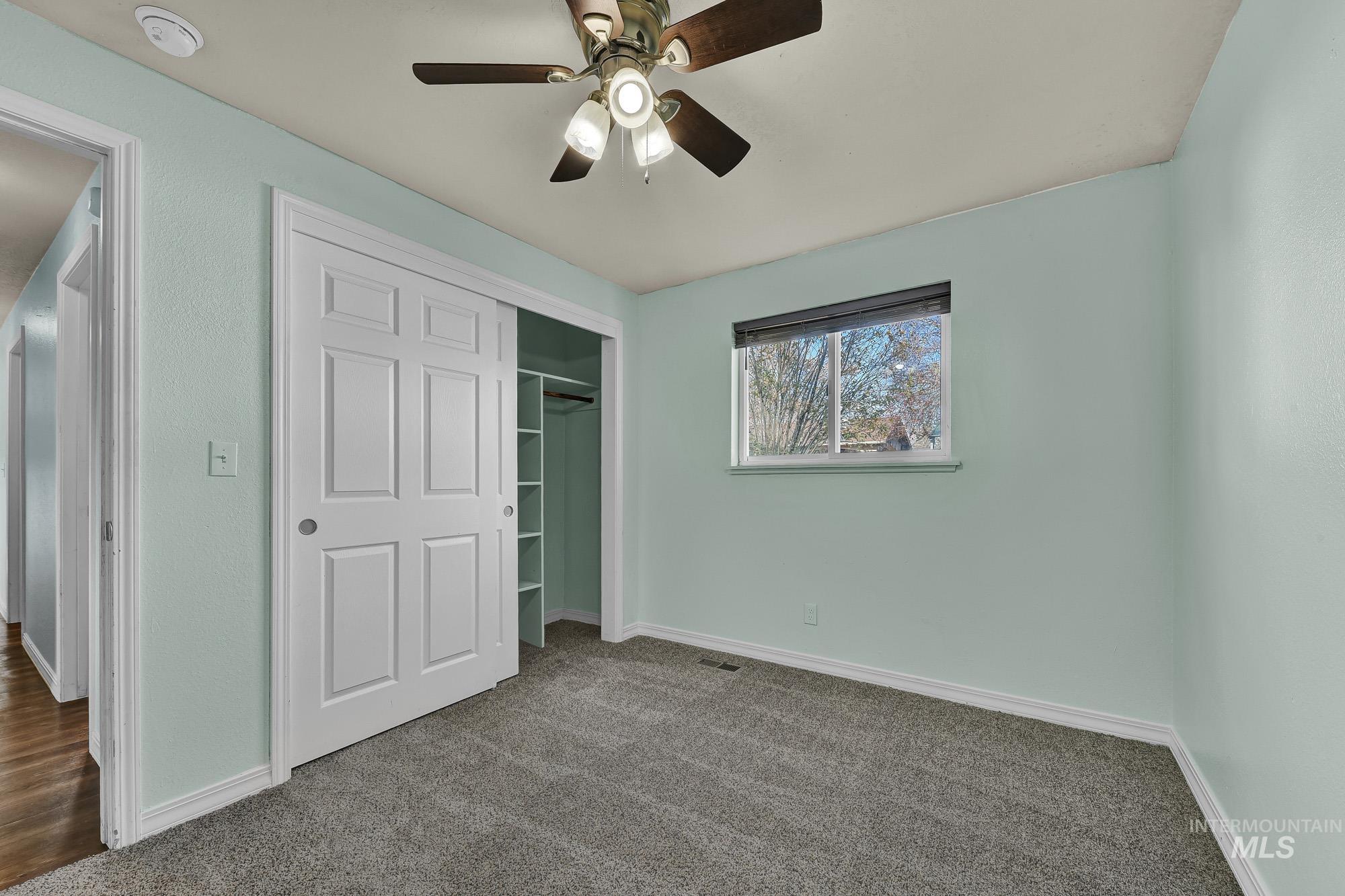 Unfurnished bedroom with new carpet, a closet, and ceiling fan
