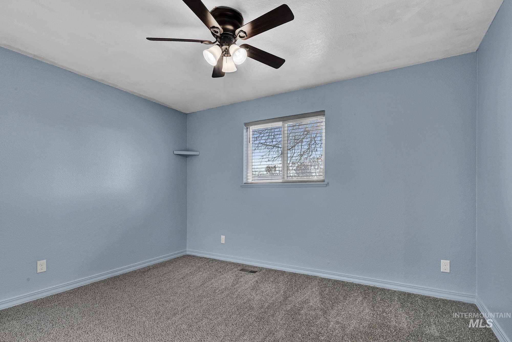 Newly Carpeted bedroom featuring nice window and ceiling fan