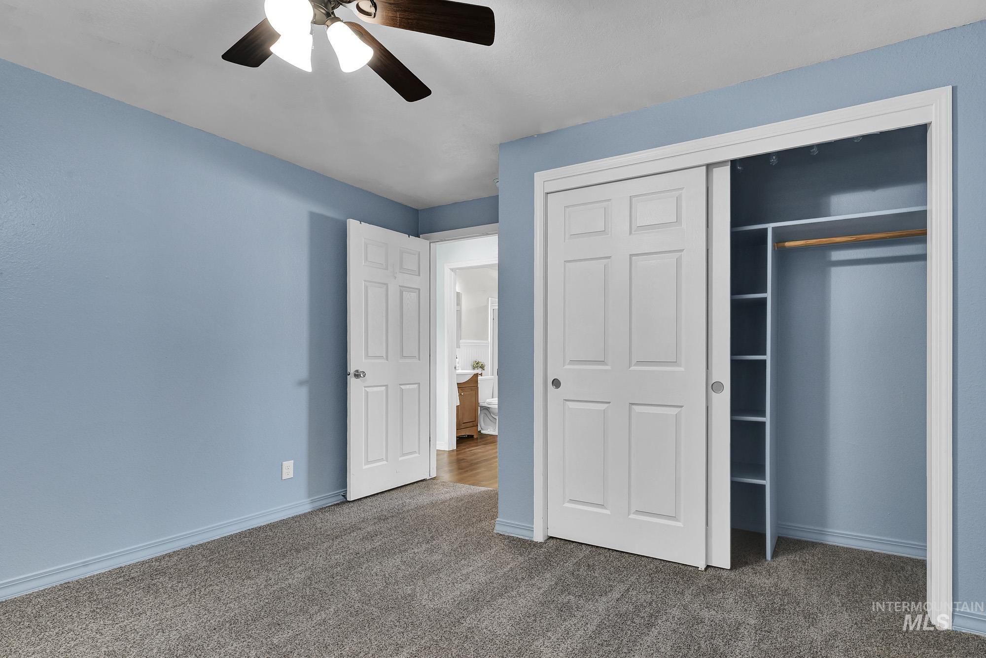 Unfurnished bedroom featuring a closet, new carpeted floors, and ceiling fan