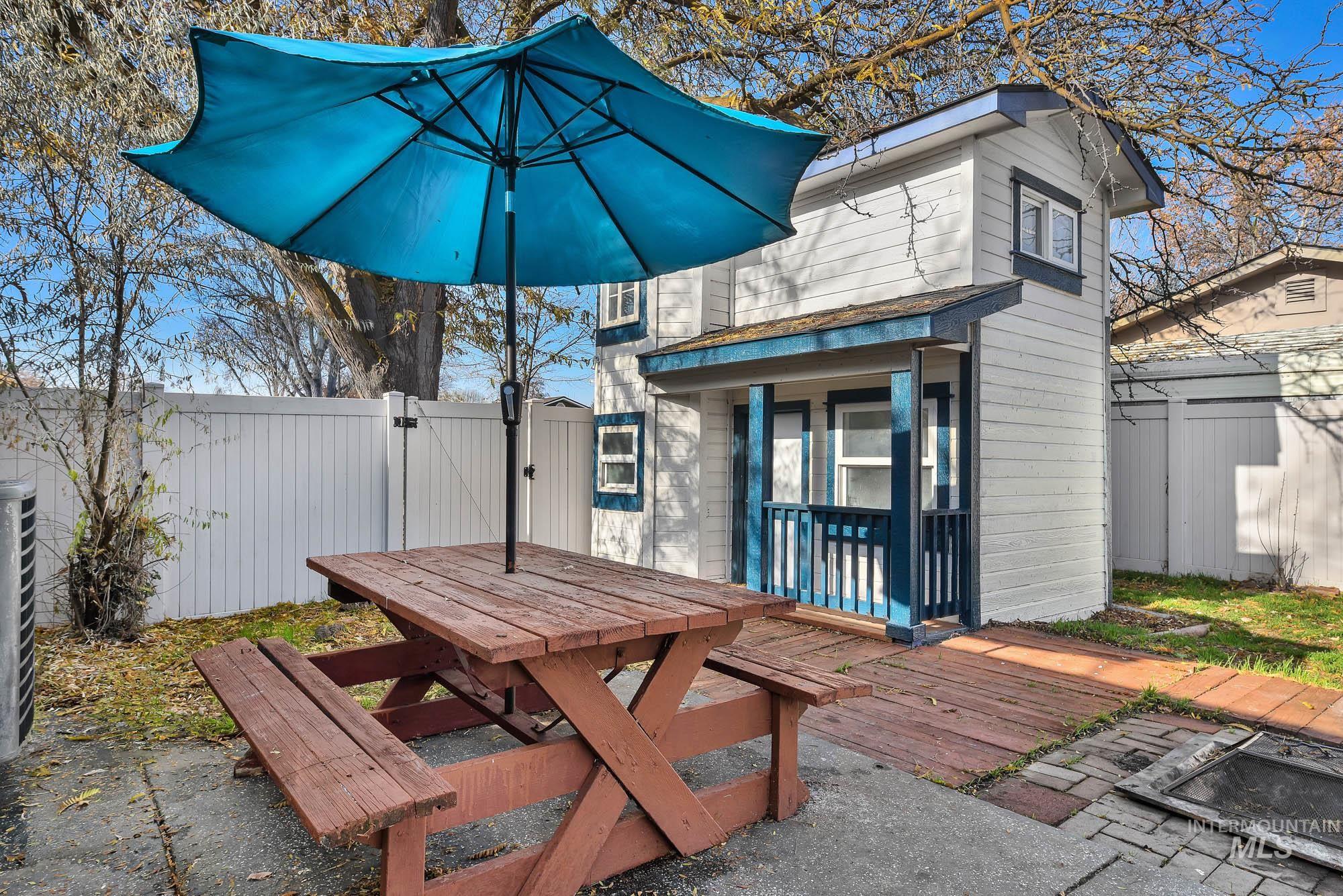 Concret patio extending to a nice Deck featuring a gate and outdoor dining space