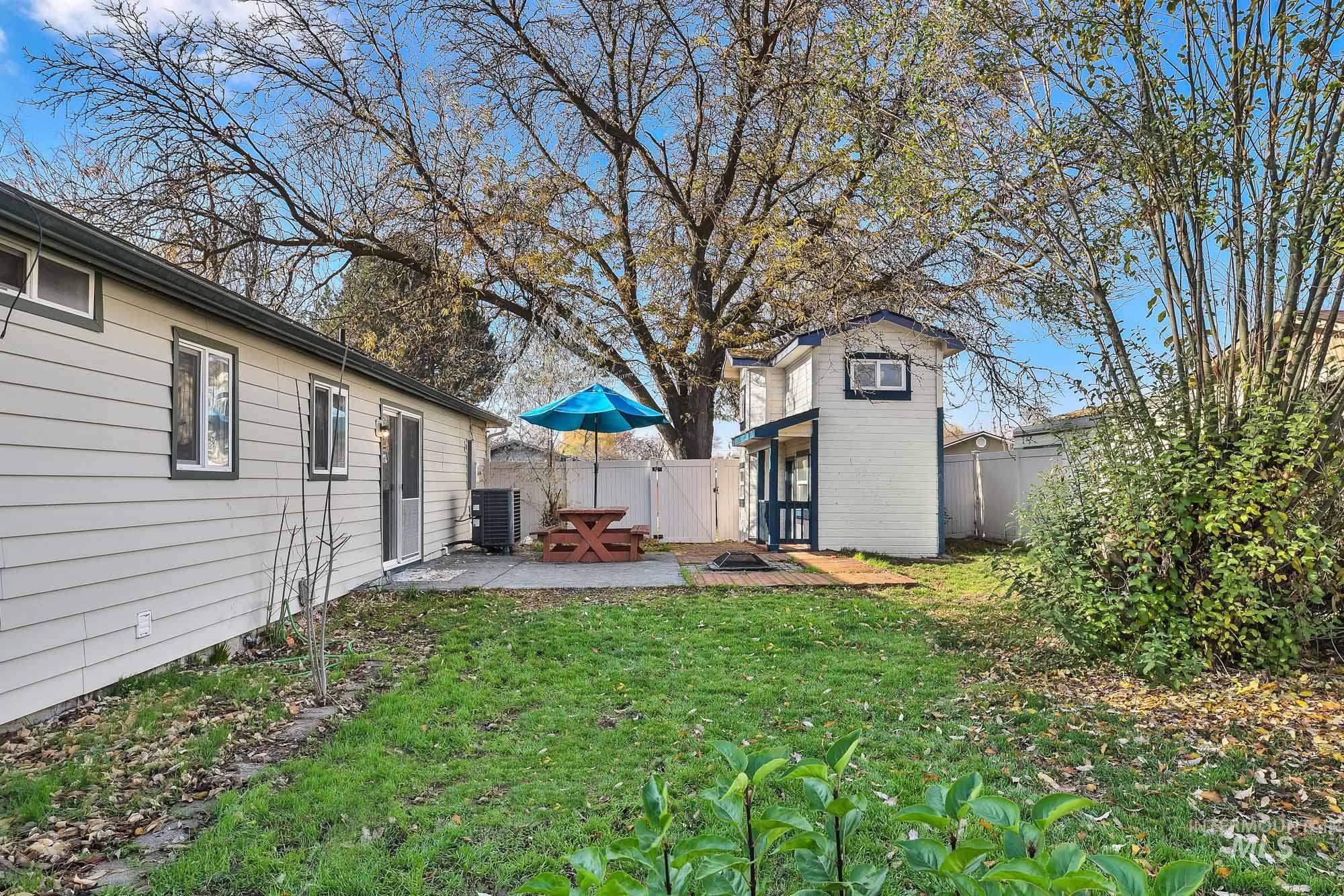 Fenced backyard with a patio area and an outbuilding