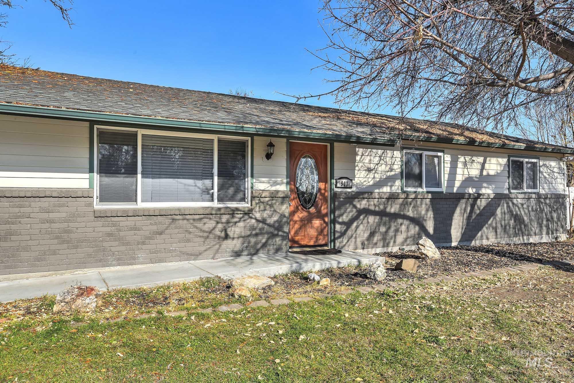 View of front walkway featuring brick siding, a front yard, and roof covering the front walk