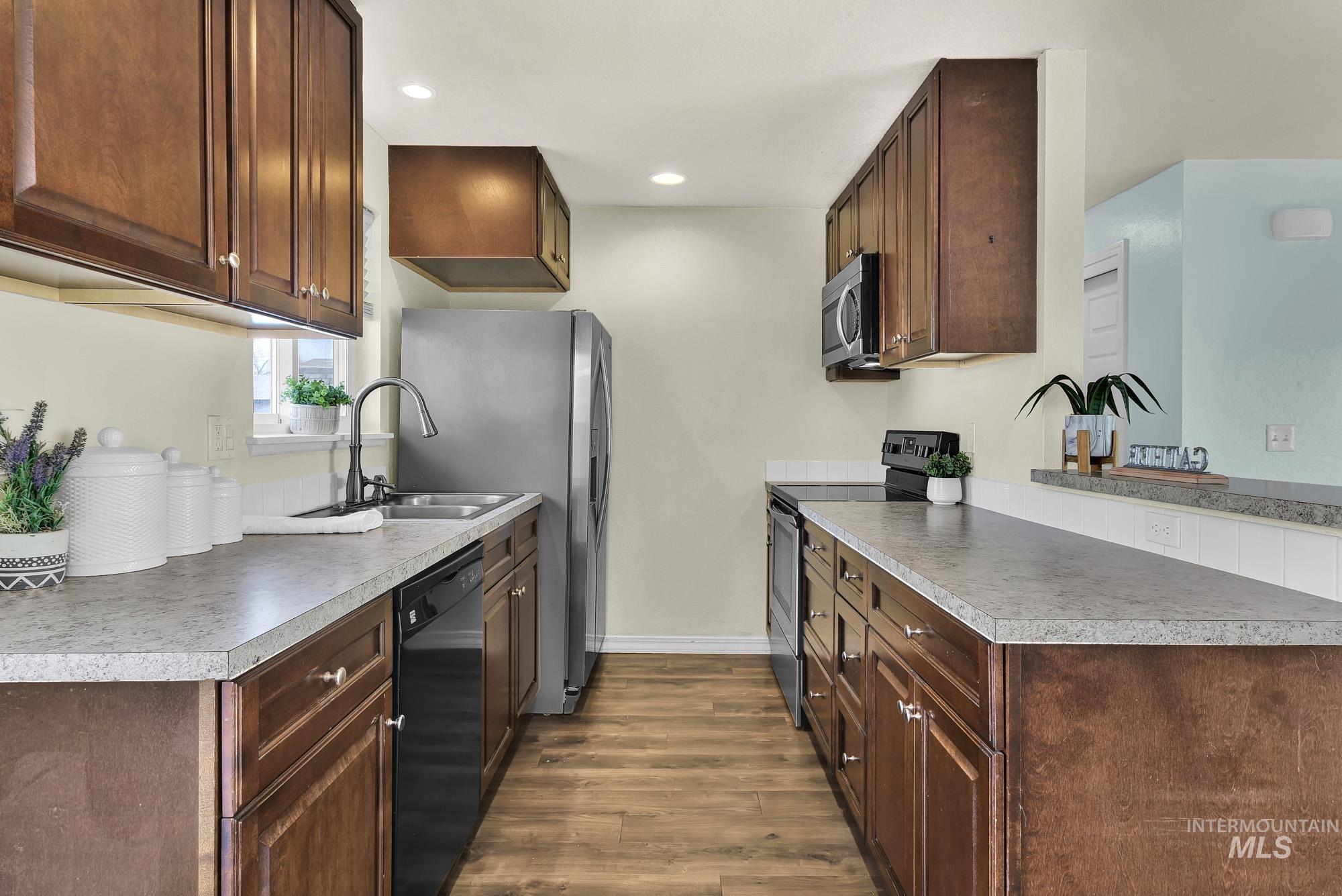 Kitchen featuring appliances with stainless steel finishes, rich maple finished cabinetry, recessed lighting, and light countertops