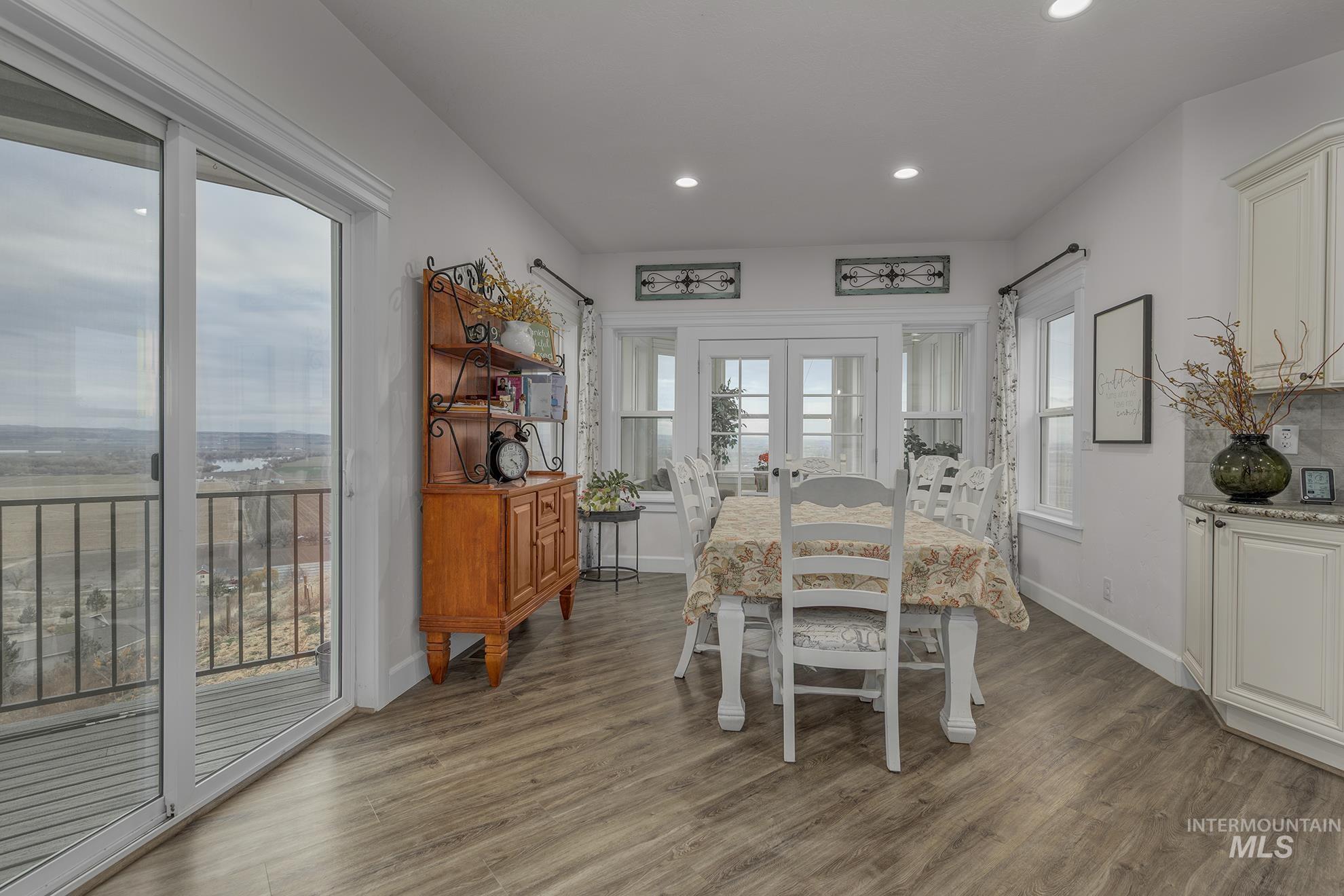 Dining space with dark wood-style flooring, french doors, and recessed lighting