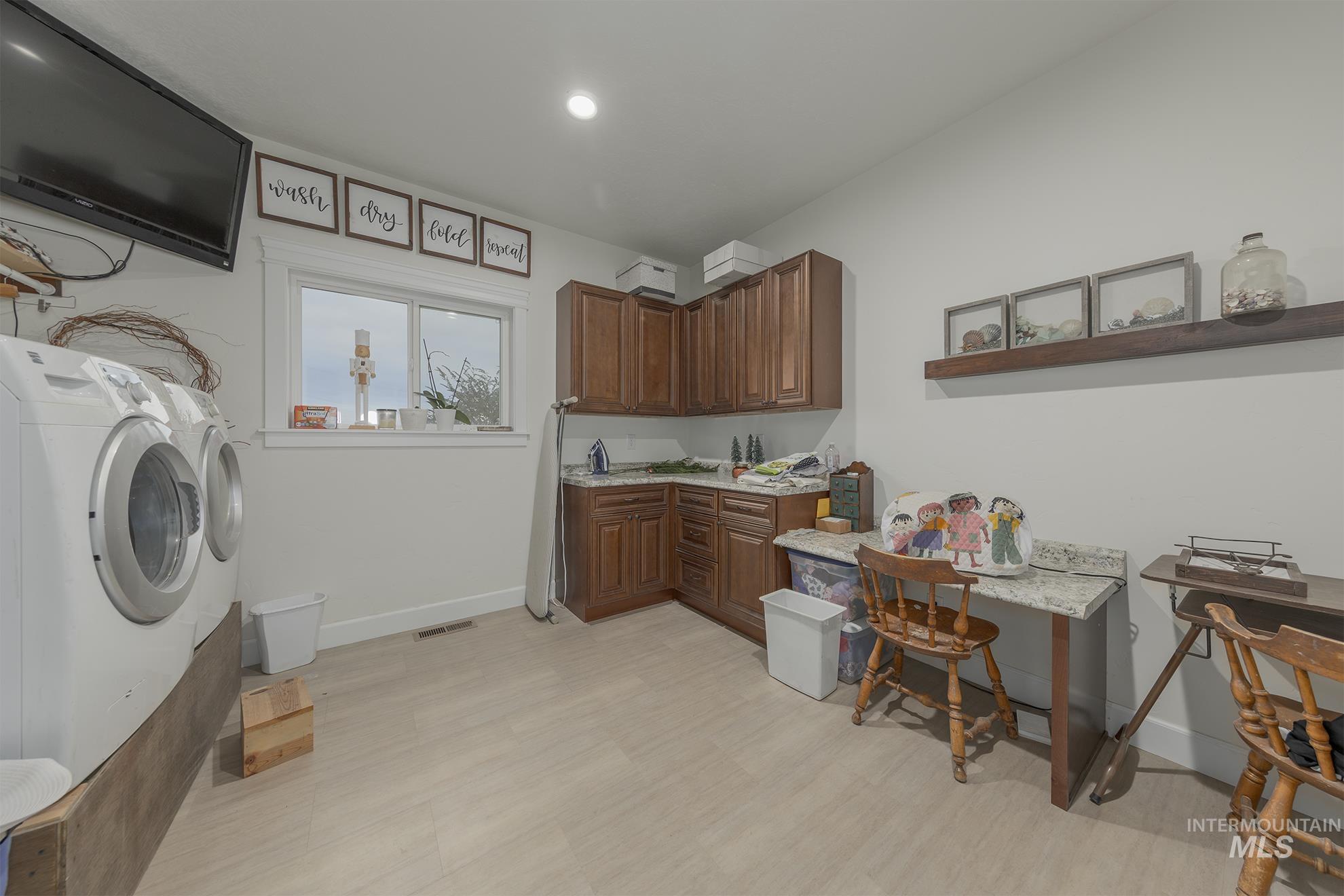 Washroom featuring separate washer and dryer, cabinet space, and recessed lighting