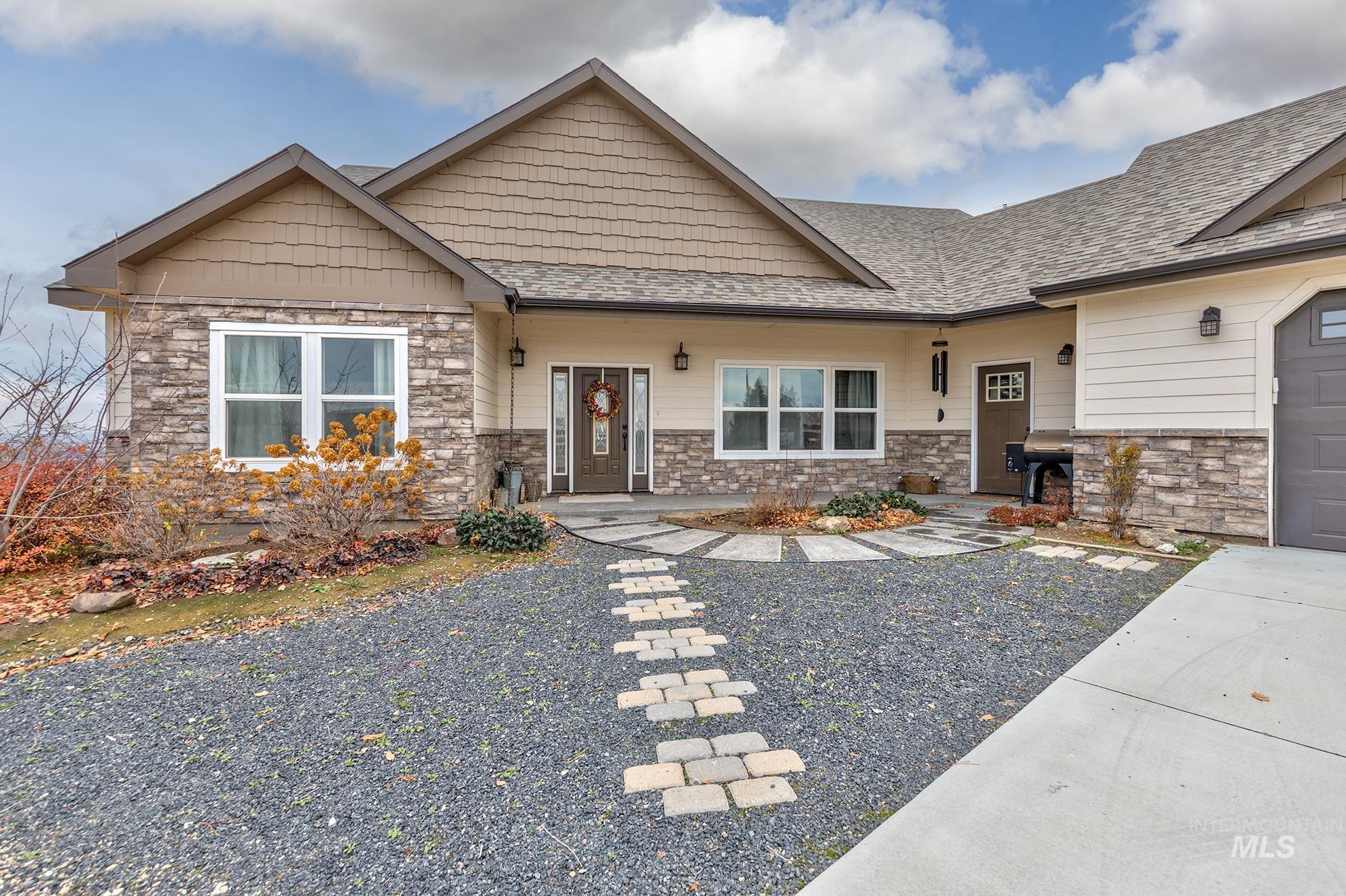 Craftsman house with stone siding and a shingled roof