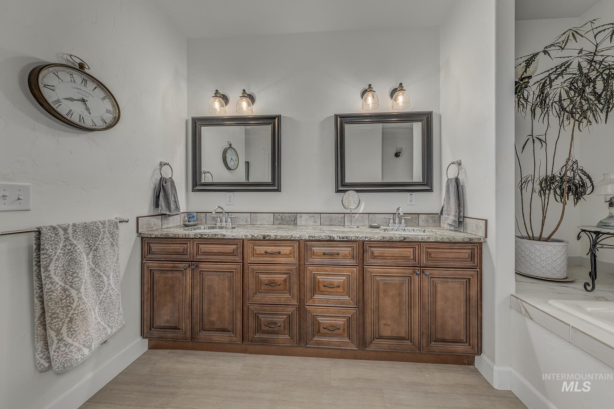 Full bath featuring double vanity and a bath