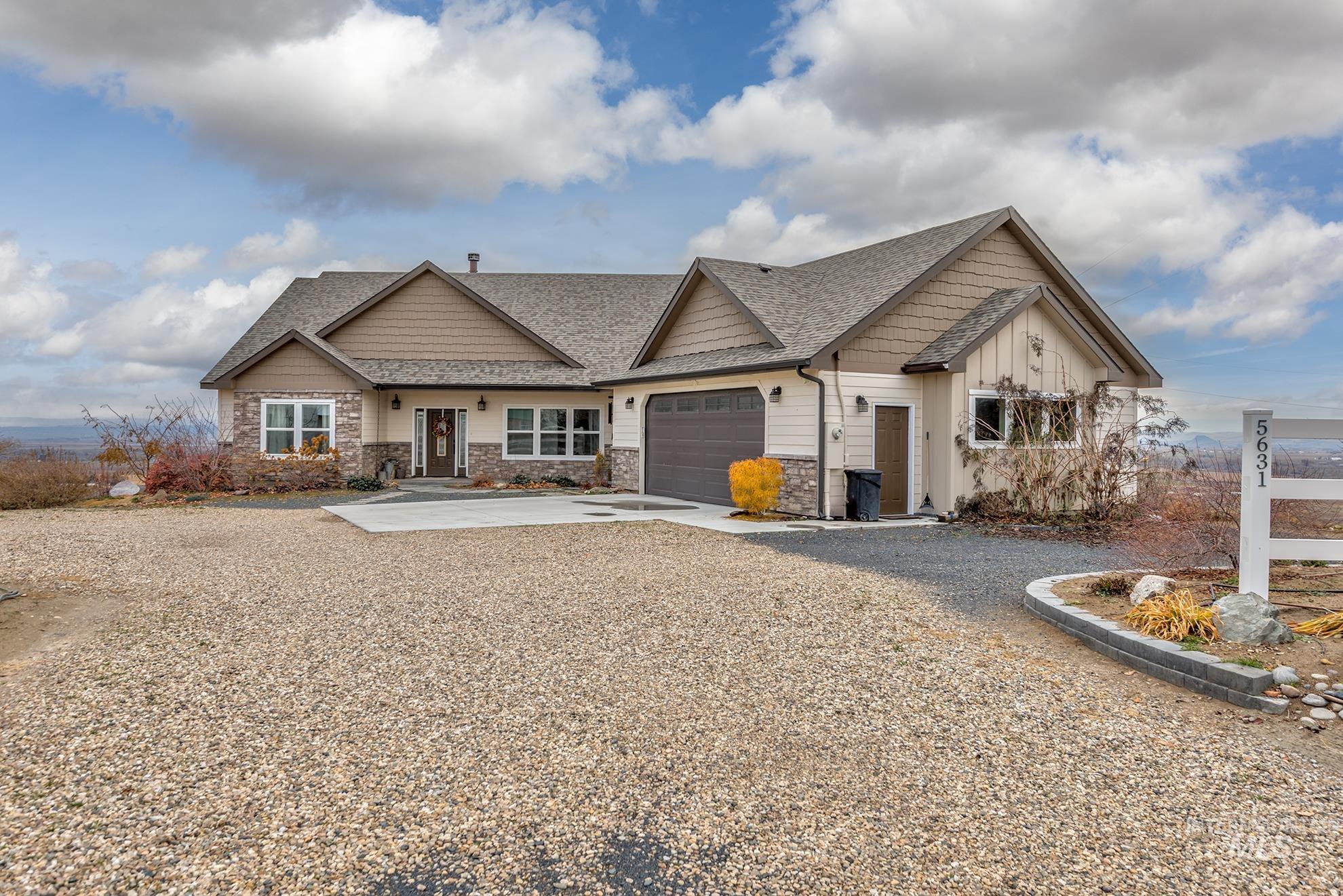 Craftsman-style house with roof with shingles, concrete driveway, stone siding, an attached garage, and board and batten siding