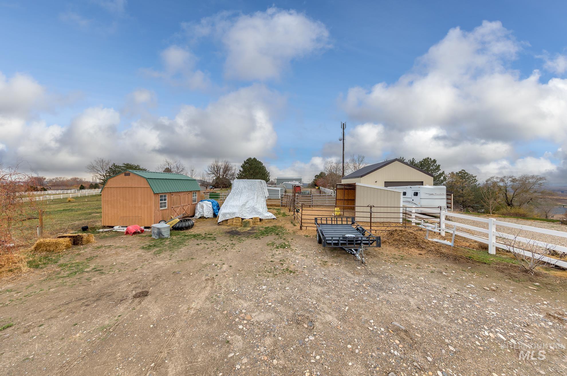 View of yard with a garage, a rural view, and a storage shed