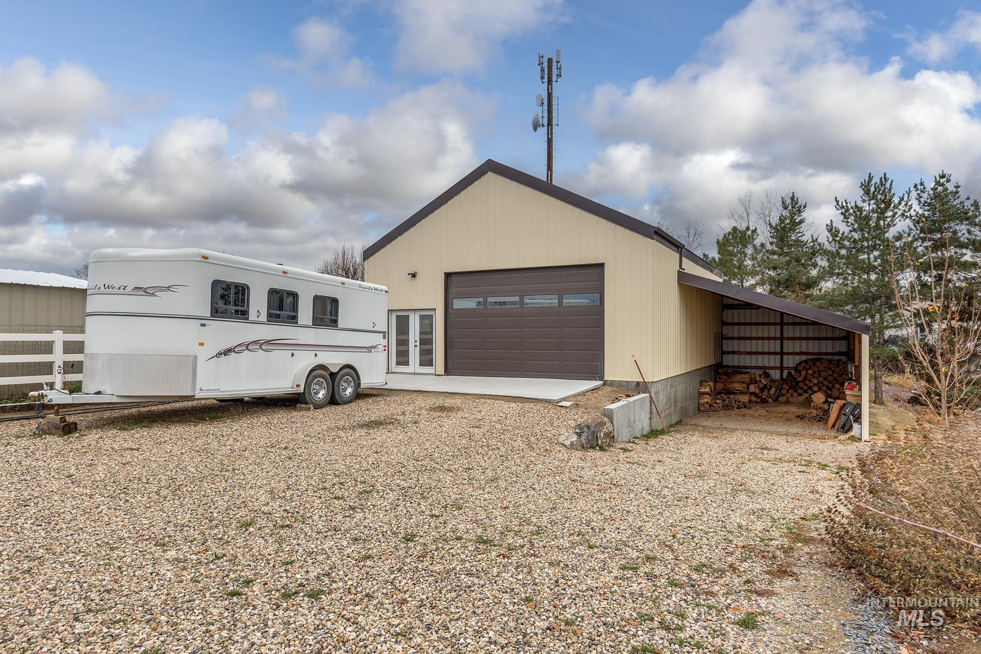 Back of property featuring a garage and an outbuilding