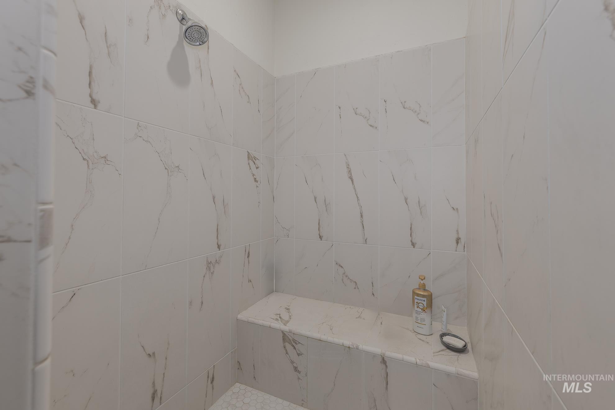 Full bath featuring a marble finish shower