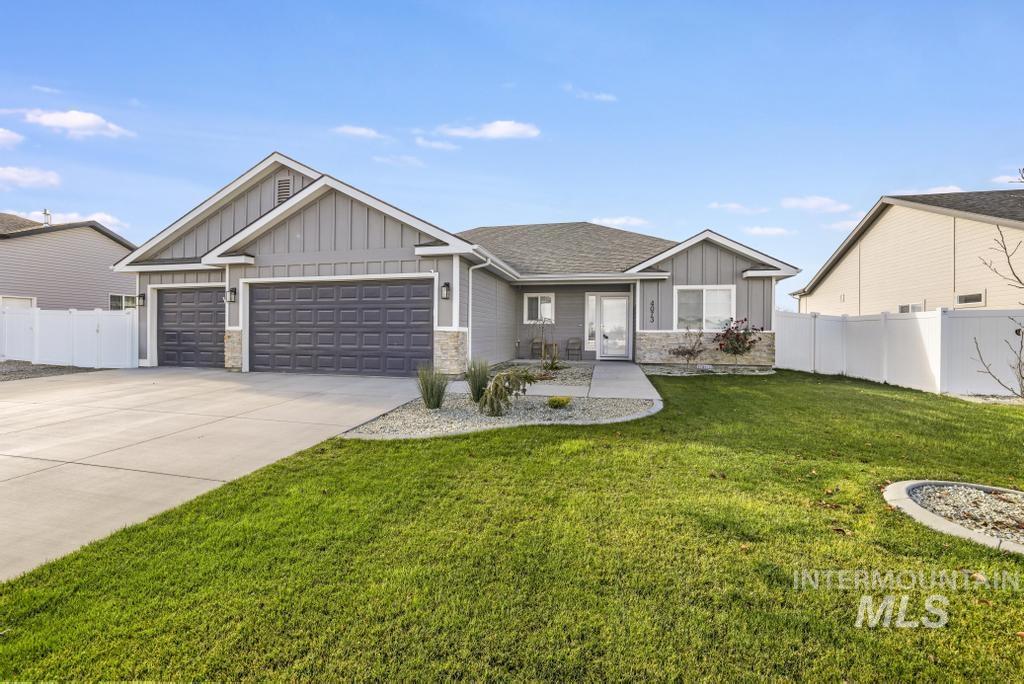 View of front facade with board and batten siding, stone siding, an attached garage, concrete driveway, and a shingled roof