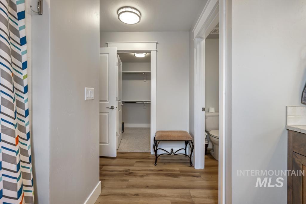 Corridor with light wood-style flooring and baseboards
