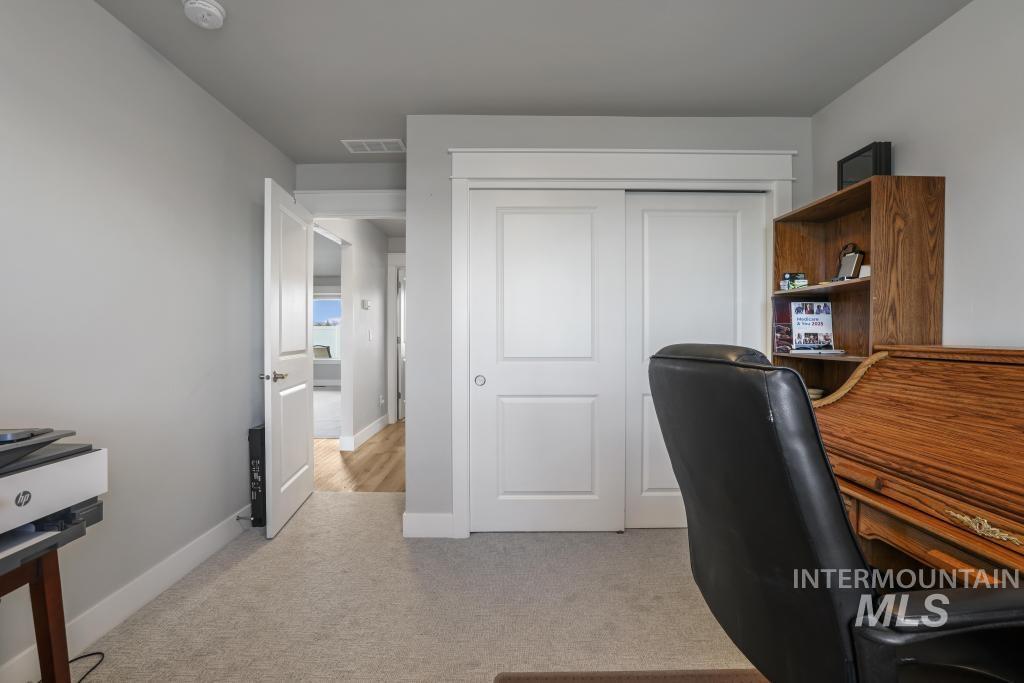 Office area featuring light carpet and baseboards