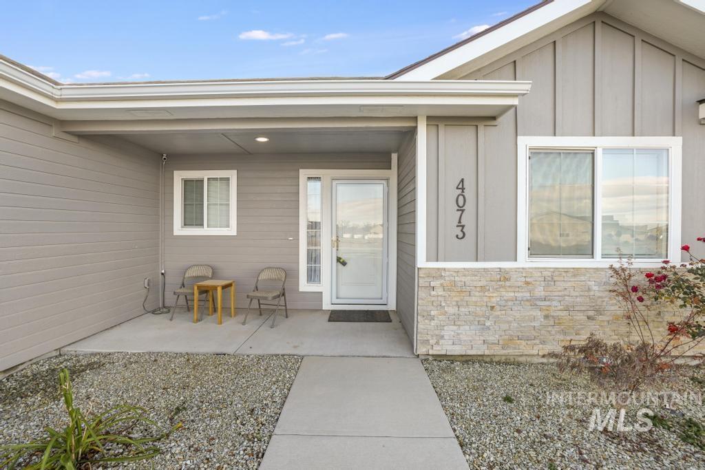 Property entrance featuring board and batten siding, stone siding, and a porch