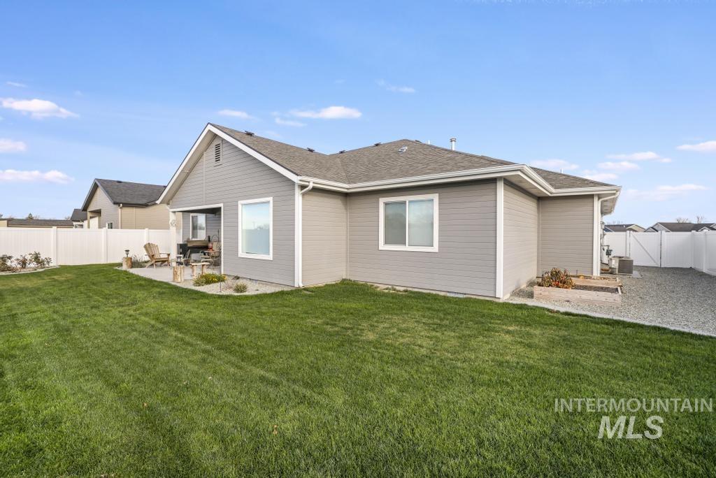 Back of property with a fenced backyard, a patio, and roof with shingles