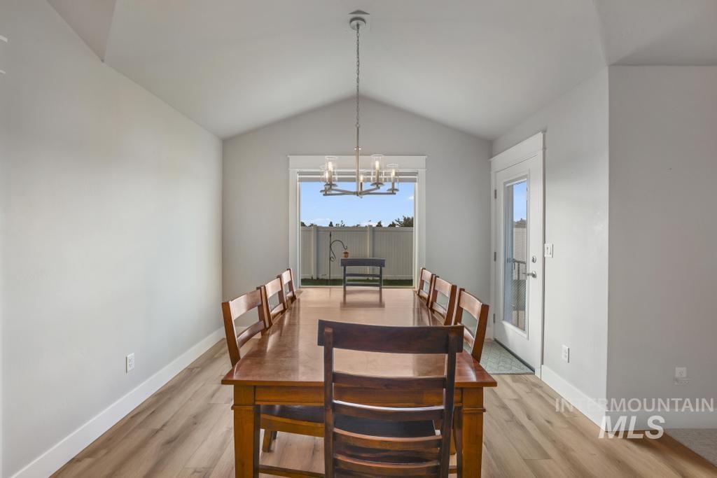 Dining room with a chandelier, lofted ceiling, and light wood finished floors