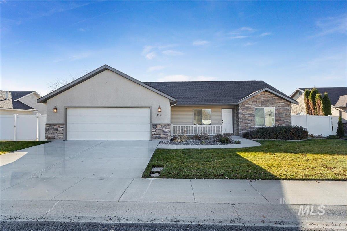 Ranch-style home featuring stone siding, concrete driveway, a garage, stucco siding, and a shingled roof