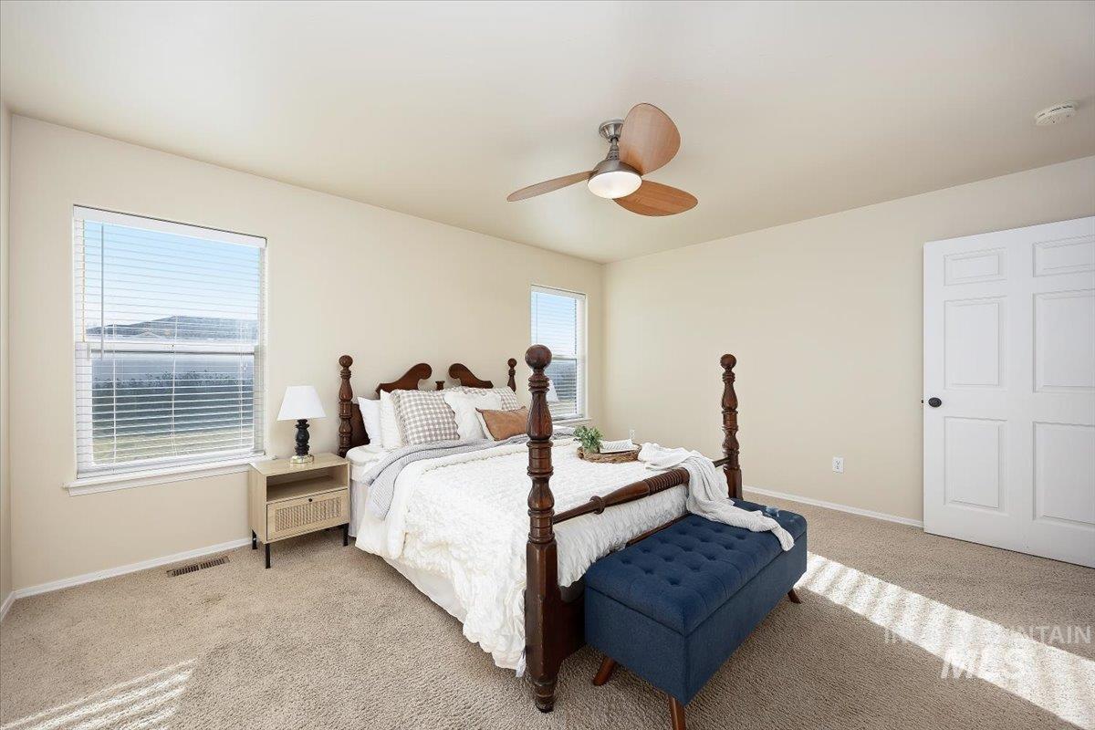 Carpeted bedroom featuring baseboards and a ceiling fan