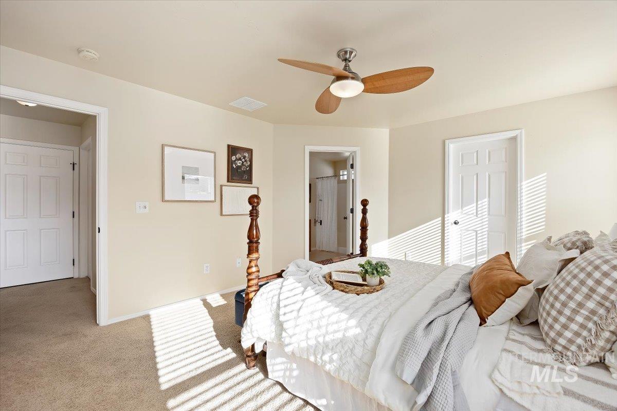 Bedroom with carpet floors, a closet, ceiling fan, and ensuite bath