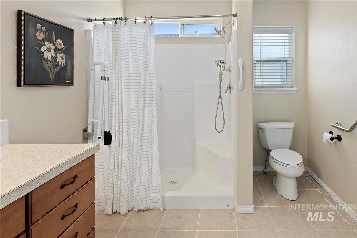 Full bathroom with vanity, a shower stall, and light tile patterned flooring