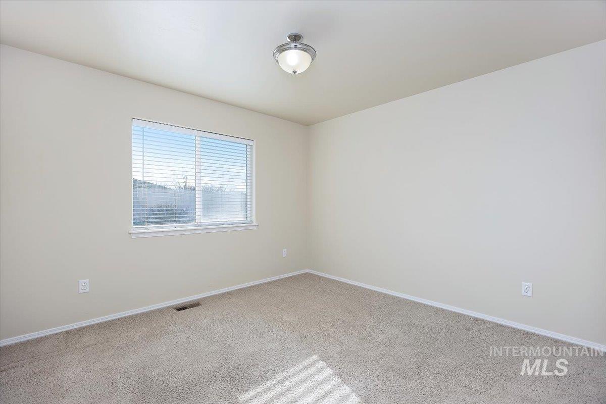 Carpeted empty room featuring baseboards